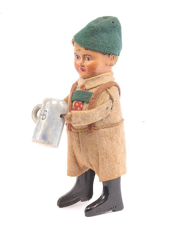 Schuco 982/6 Clockwork Tyrolean Boy with Stein: Schuco - 982/6 - Clockwork Tyrolean Boy with Beer Stein - beige felt shirt - light brown shorts - green cap - holding blue/grey china beer stein - marked HB - generally VG - minor marks to face - in w