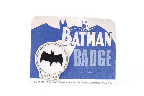National Periodical Publications Batman Badge: National Periodical Publications Batman Badge, 1966, white plastic pin badge with Batman emblem in black, gold outer rings with BATMAN lettering to base, upon original blue mono printed card, metal fi