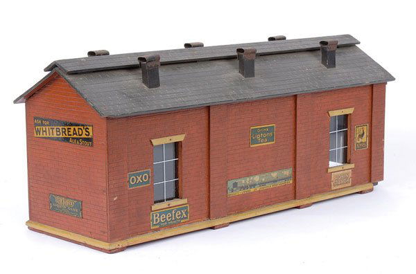 Bassett-Lowke Single Road Wooden Engine Shed: Bassett-Lowke O Gauge single road wooden Engine Shed fitted with a number of enamel signs including "Model Railway Ship Engines", "Singer Sewing Machines", "Rowntrees Chocolates", "Sertofix Liquid Glu