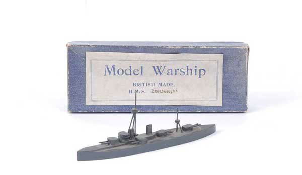 Bassett-Lowke "HMS Dreadnought": Bassett-Lowke wooden Waterline Ship HMS Dreadnought in battleship grey with Bassett-Lowke label to base. In earliest type all blue box with white label "Model Warship - British Made", box is Good to G