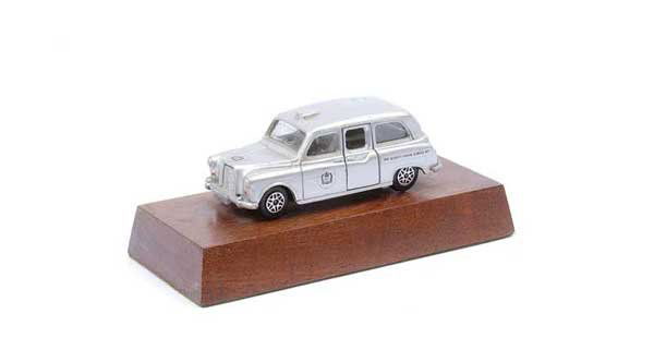 Dinky Austin Taxi "Queen's Silver Jubilee 1977": Dinky Austin "Taxi" - silver "The Queen's Silver Jubilee 1977" - grey interior, union jack decal to boot - although this appears to be a standard issue model it is mounted on wooden plinth which is be