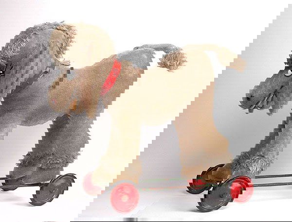 Schuco - Donkey on Wheels: Schuco - Donkey on Wheels - 1950's - black and white comical glass eyes - nostrils - airbrushed features - felt mouth - wired ears - grey mohair - on metal wheel base with rubber tyres - wearing red p