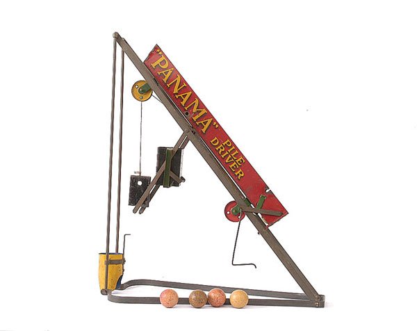 Wolverine Panama Pile Driver: Wolverine Panama Pile Driver - tinplate/pressed steel structure with red/green shoot, with a number of wooden balls, pulley wheel and metal weight. Unusual toy, 40cm high, generally Good.