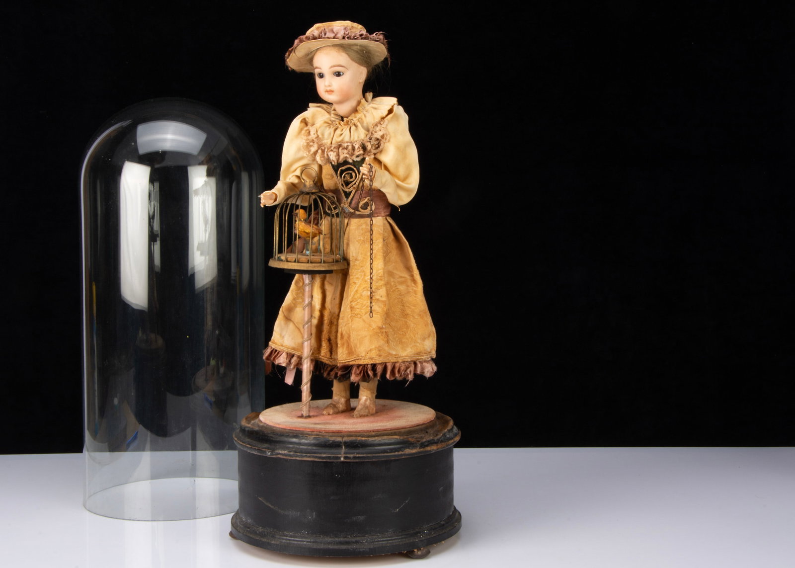 A reproduction automaton of of a girl with birdcage,: A reproduction automaton of of a girl with birdcage, possibly by Reuge, with reproduction Jumeau bisque head, the head nods and moves from side to side, her arms move up and down and the bird moves an