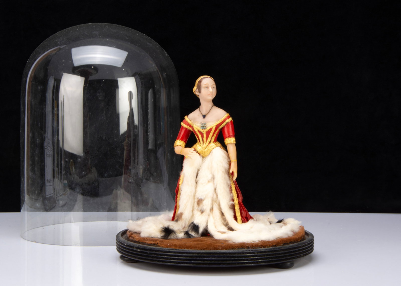 A Henrietta Wade wax model of Queen Victoria in Robes of State,: A Henrietta Wade wax model of Queen Victoria in Robes of State, her head turned to the right, coloured waxes applied to form hair and delicate material, under glass dome —14in. (35.5cm.) overall