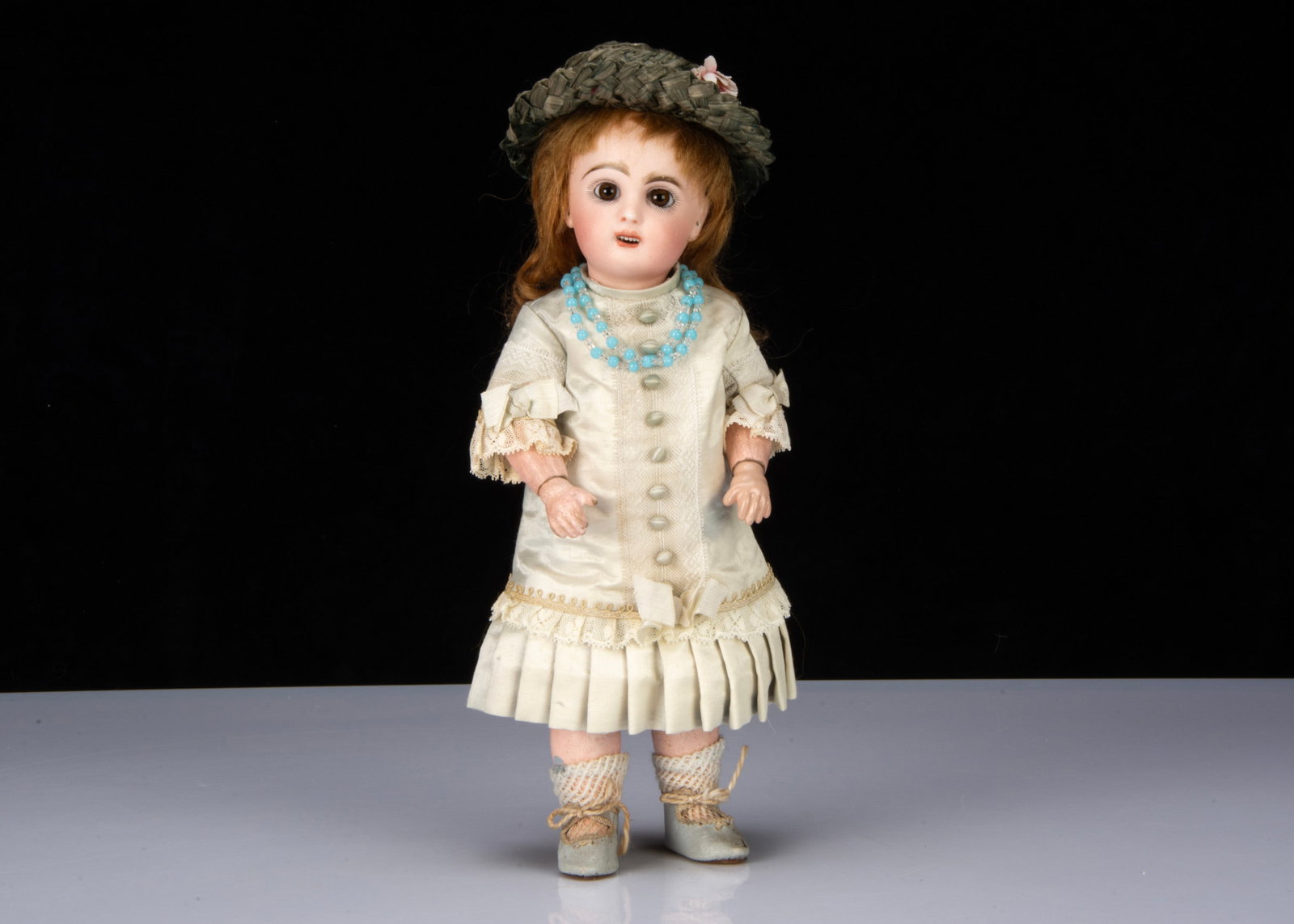 A small unmarked Jumeau bebe No.2,: A small unmarked Jumeau bebe No.2, with fixed striated brown glass eyes, brown feather brows, open mouth with teeth, pierced ears, back of head impressed 2 with red painter’s mark, original aubu