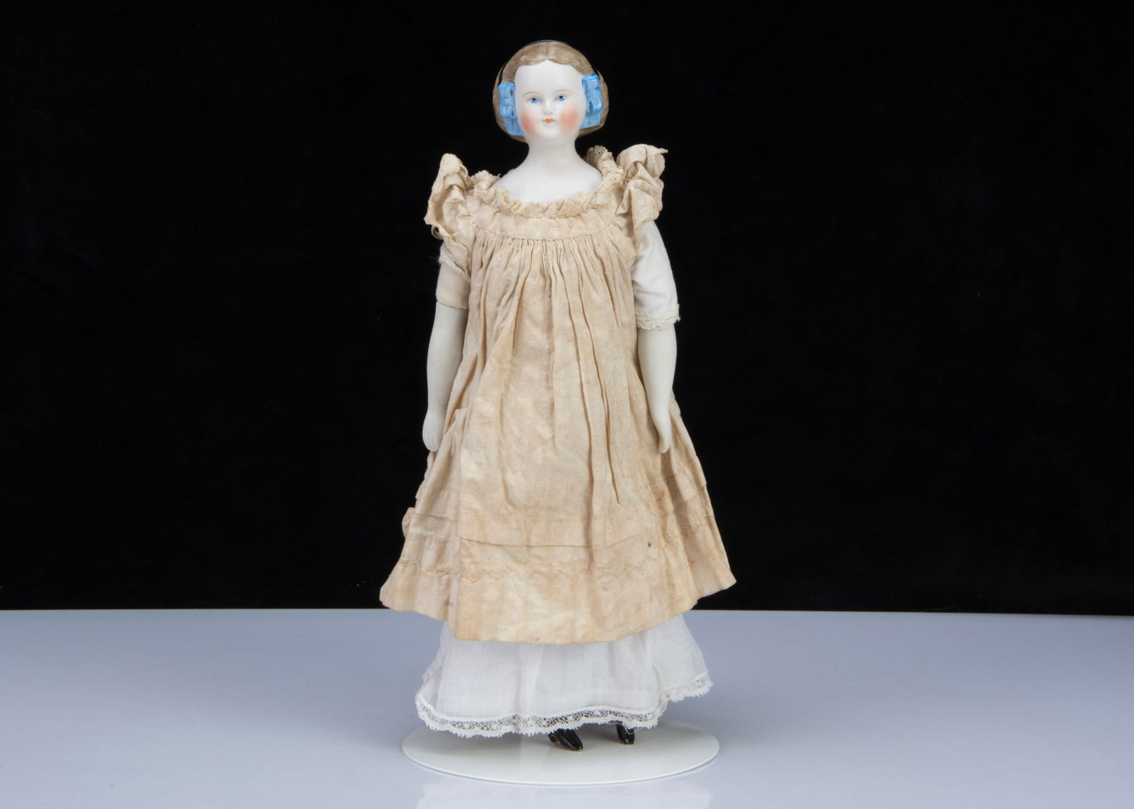 A late 19th century German bisque shoulder head doll with net snood and ribbons in hair, (1 of 3)