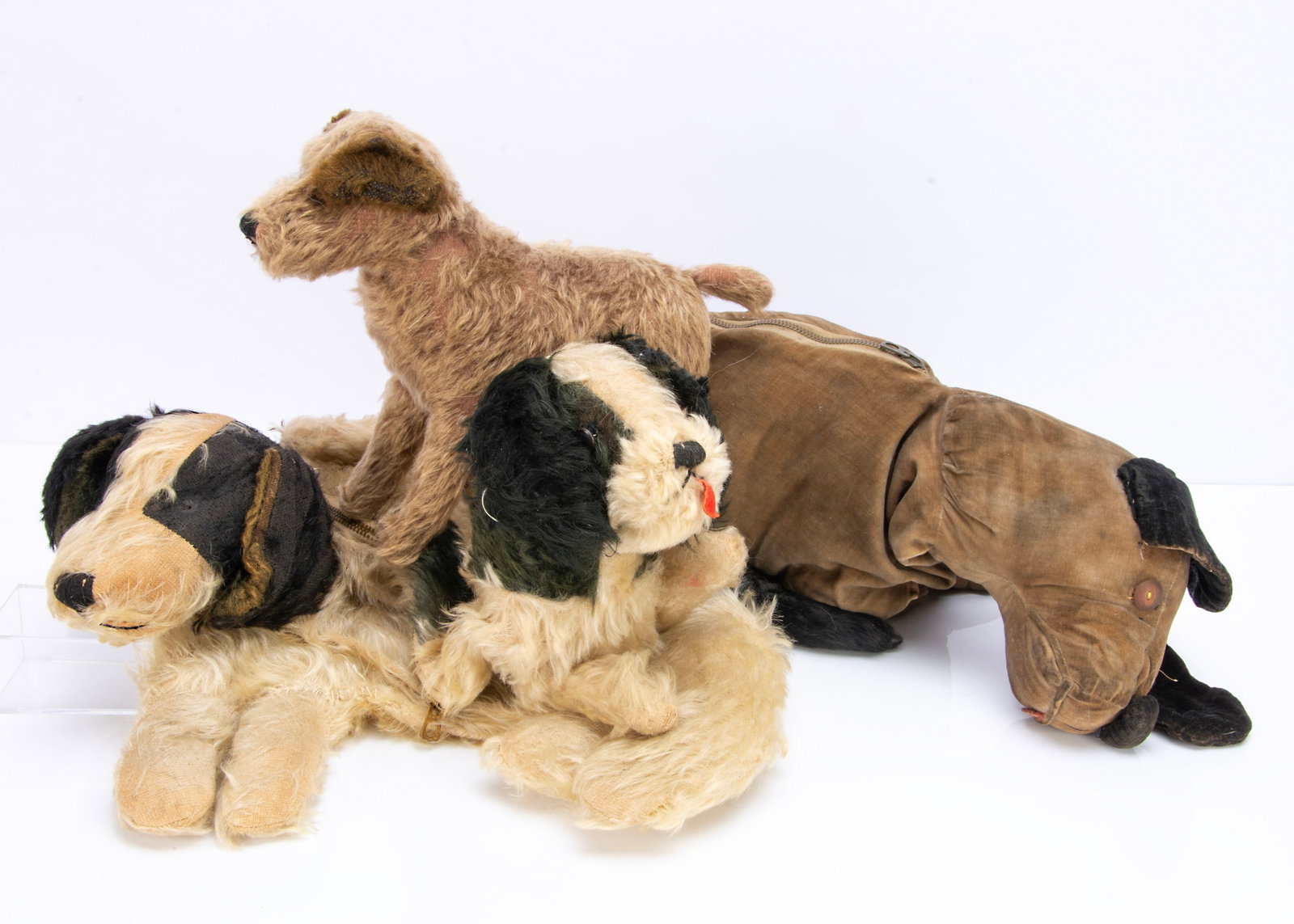 A British 1920s soft toy terrier dog,: A British 1920s soft toy terrier dog, with brown mohair, black boot button eyes, black stitched nose and mouth ó9in.(23cm.) high; and three soft toy dog pyjama cases