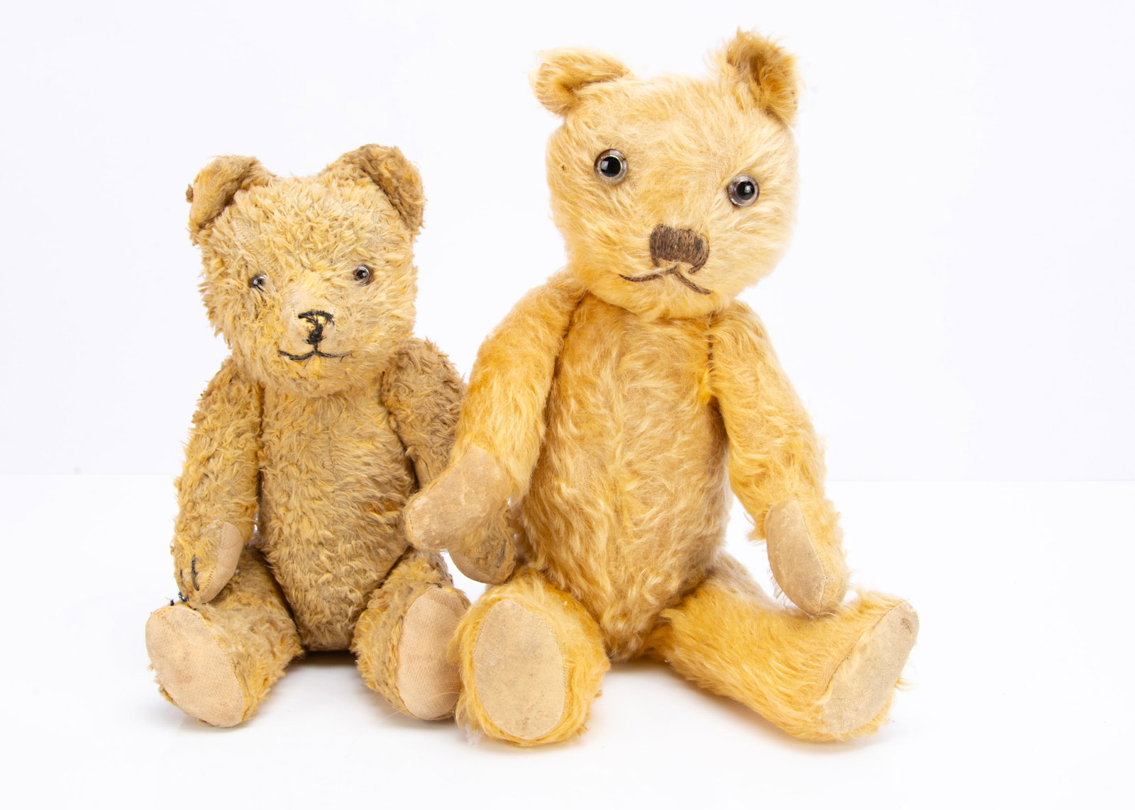 A British 1940s teddy bear,: A British 1940s teddy bear, with golden mohair, clear and black glass eyes with remains of painted backs, black stitched nose and mouth, swivel head and jointed limbs ó16in. (40cm.) high; and Eas