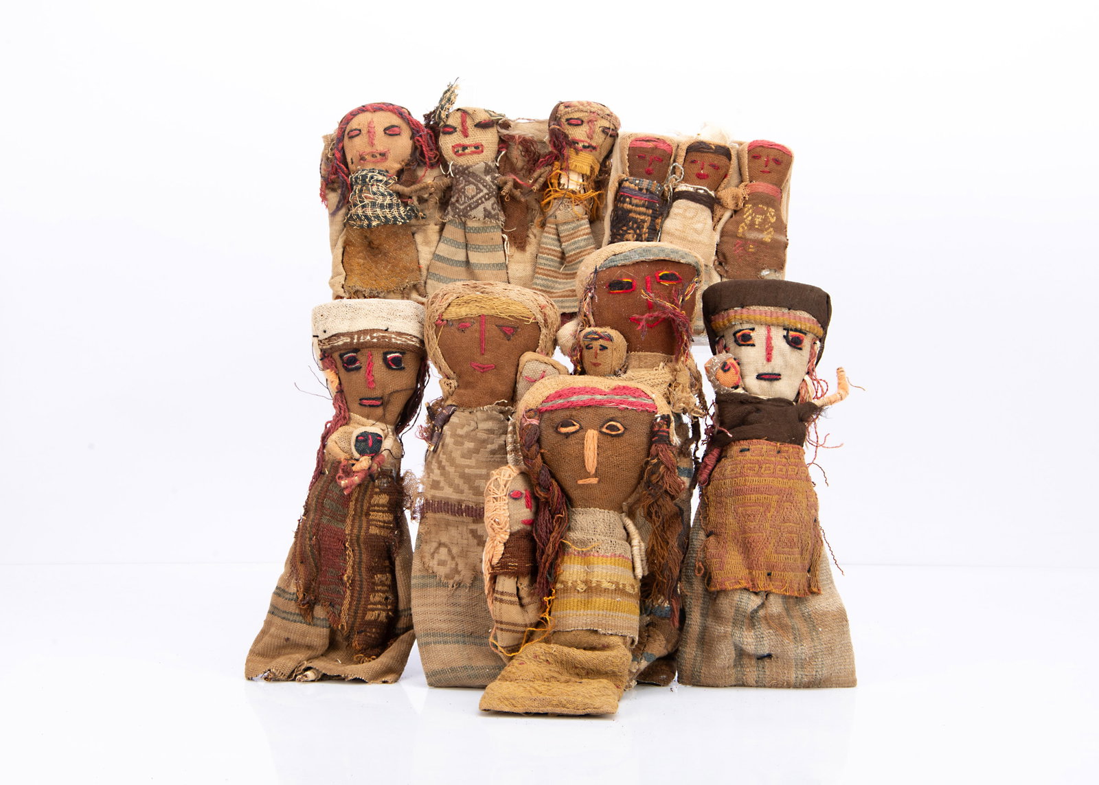 Peruvian Chancay cloth burial dolls,: Peruvian Chancay cloth burial dolls, four figures holding babies ó10in. (25cm.) high, and two groups of three lying figures (some wear)