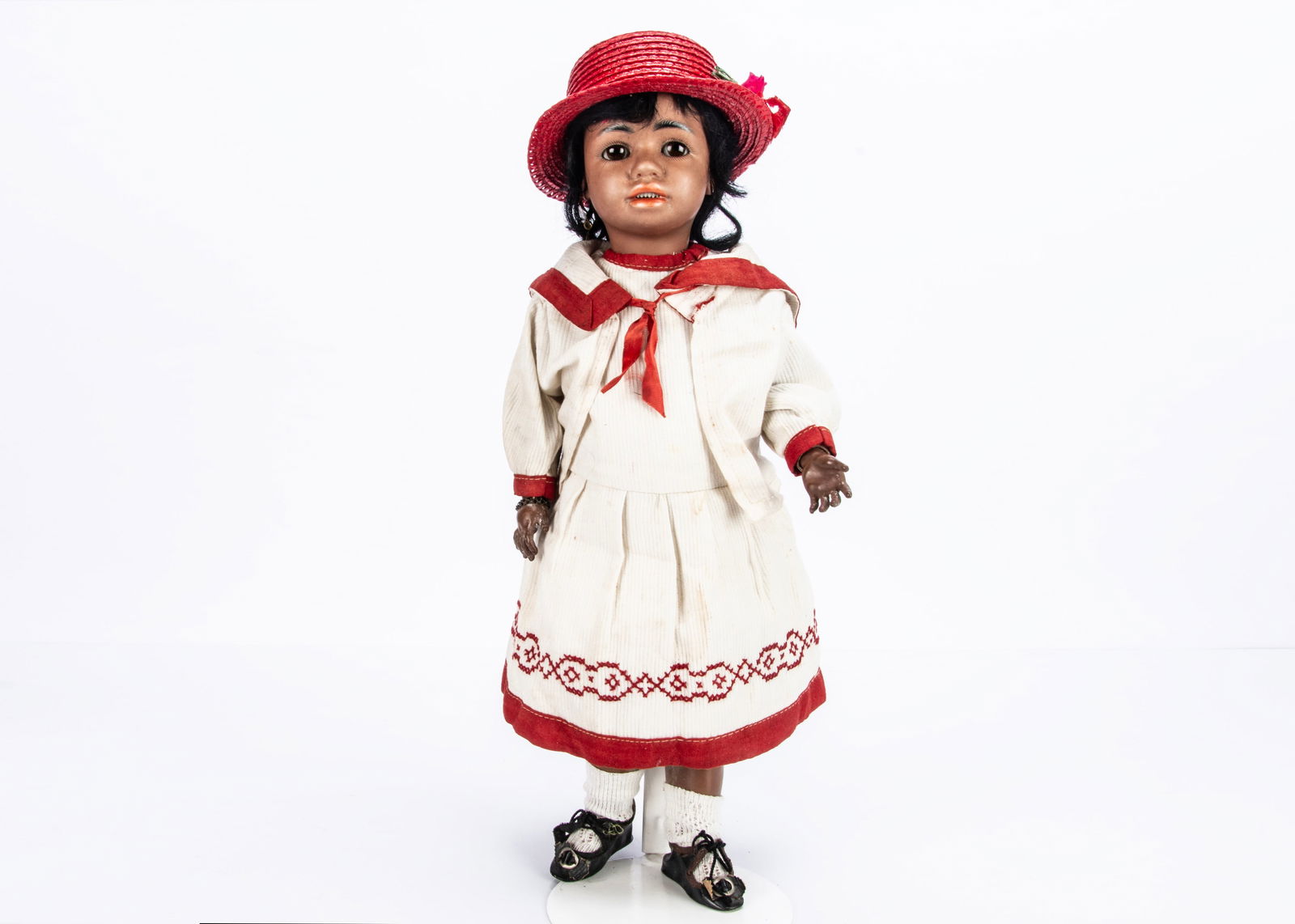 A rare Simon & Halbig black 1358 child doll,: A rare Simon & Halbig black 1358 child doll, with brown complexion, brown sleeping eyes, full pin lips, pierced ears, black mohair wig, jointed composition body, ribbed white cotton dress with red tri