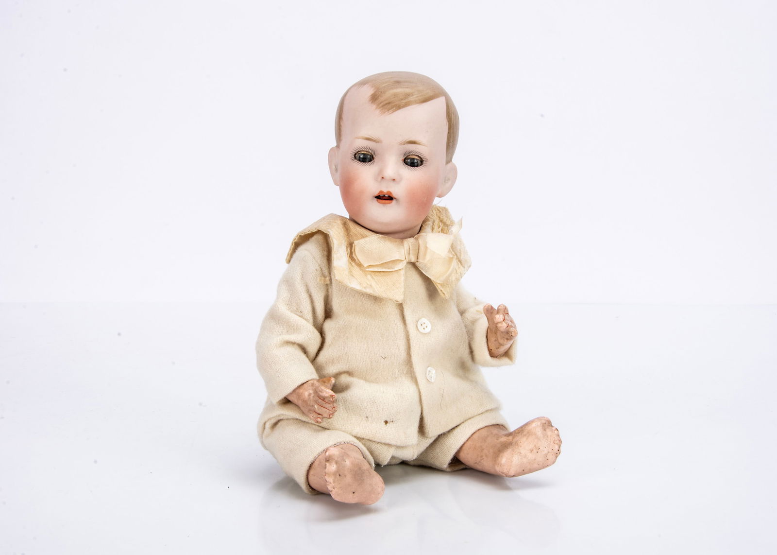 A Bruno Schmidt 2048 character baby,: A Bruno Schmidt 2048 character baby, with blue sleeping eyes, blonde painted and moulded hair, bent-limbed composition body and cream wool suit with silk collar ó9 Ωin. (24cm.) high