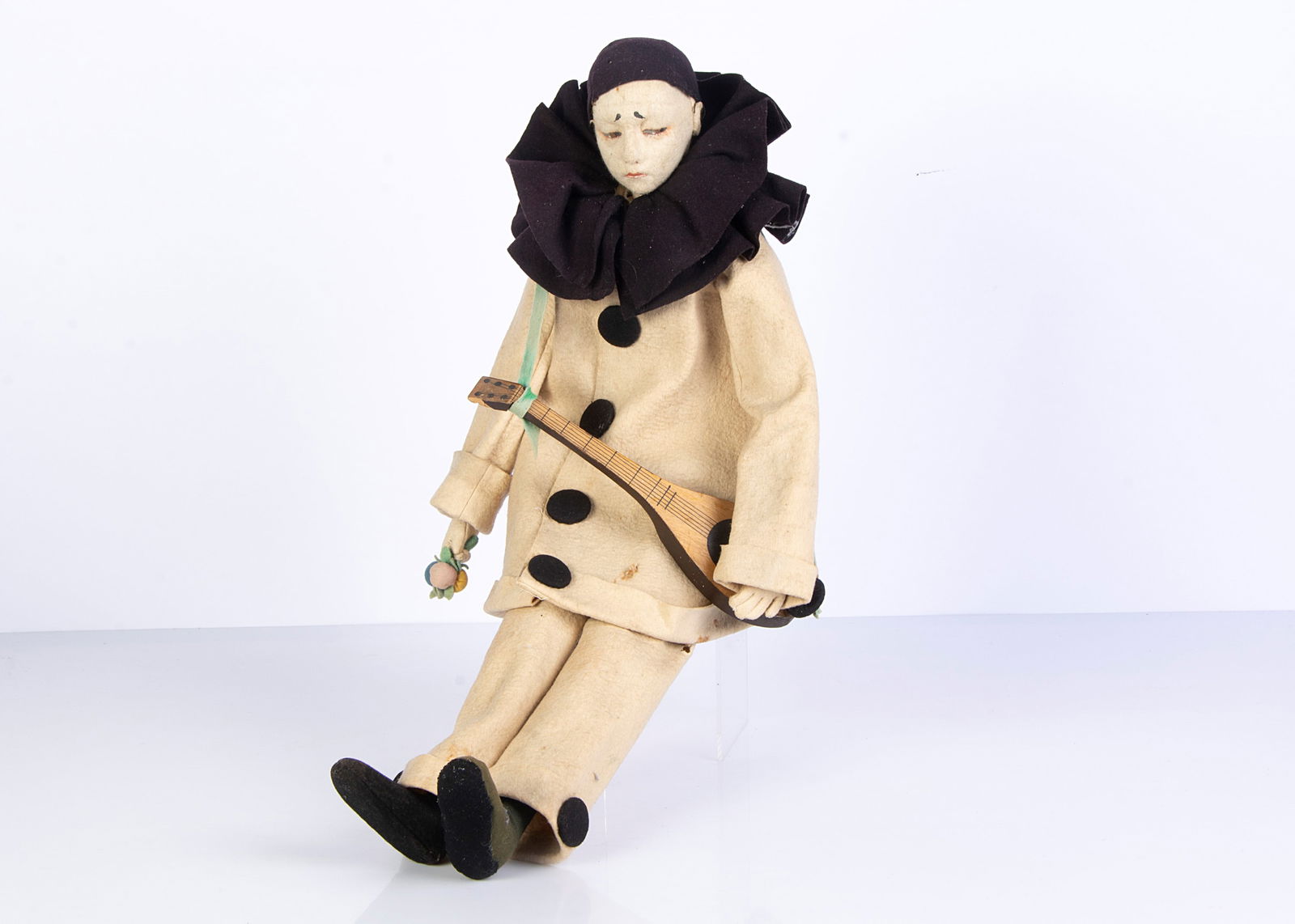 A 1920s Lenci Pierrot felt doll,: A 1920s Lenci Pierrot felt doll, with pressed felt sad face, narrowed brown painted eyes, elongated boudoir type cloth body with felt hands and boots, original white and black felt clothes and wooden