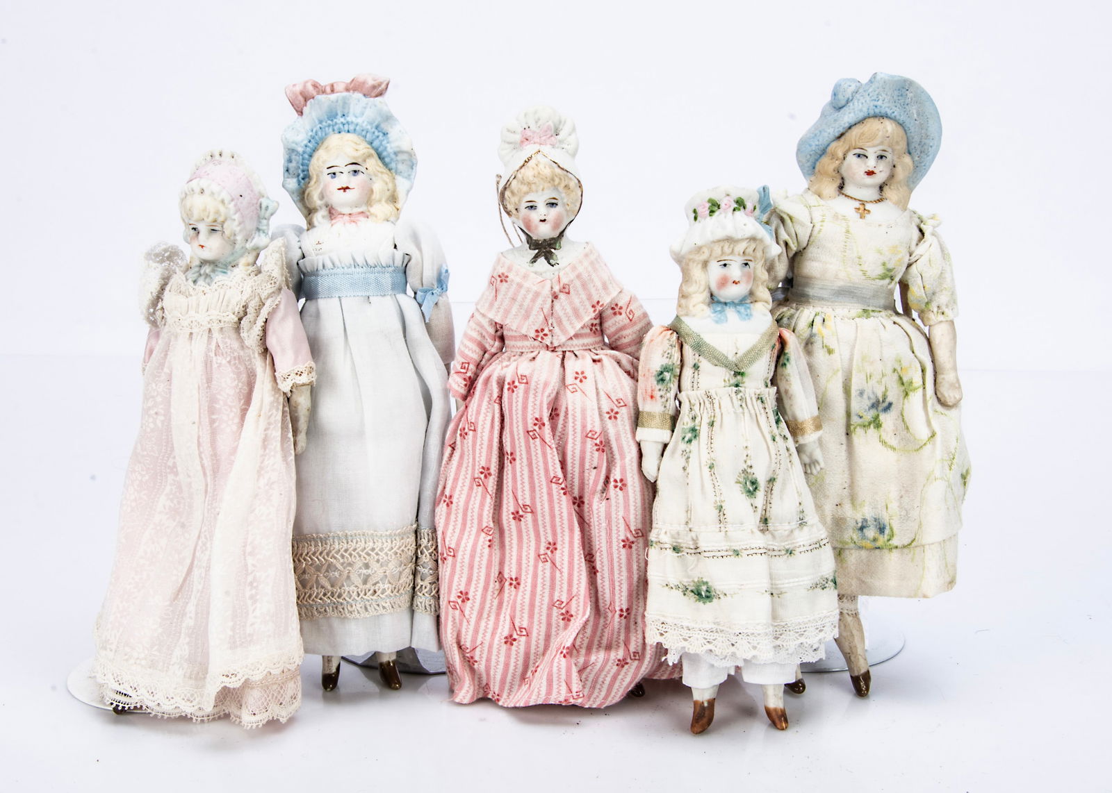 Five small bisque Hertwig shoulder-head dolls with moulded hats,: Five small bisque Hertwig shoulder-head dolls with moulded hats, with stuffed bodies with bisque limbs, nicely dress, the largest ó7 Ωin. (19cm.) high