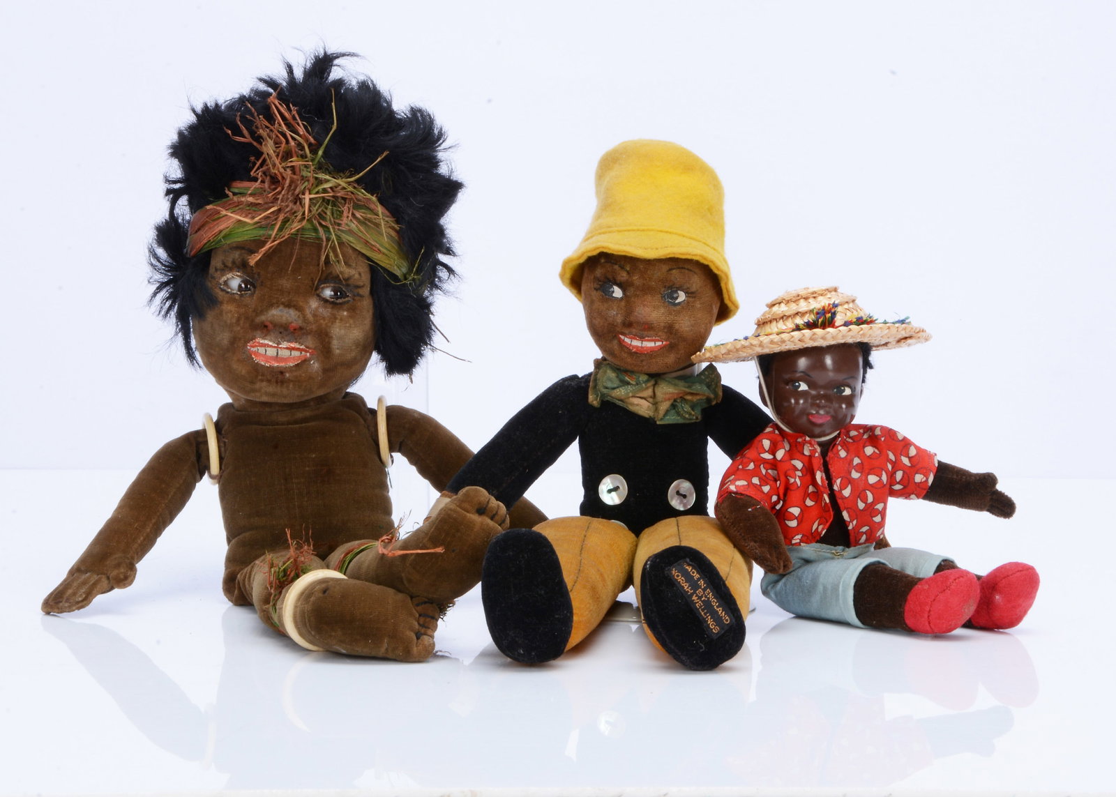 Three Norah Wellings black dolls,: Three Norah Wellings black dolls, a Sambo boy with brown velvet head and hands, black and yellow velvet body, yellow felt hat and label on foot —11 ¼in. (29cm.) high; a Southsea Islander do