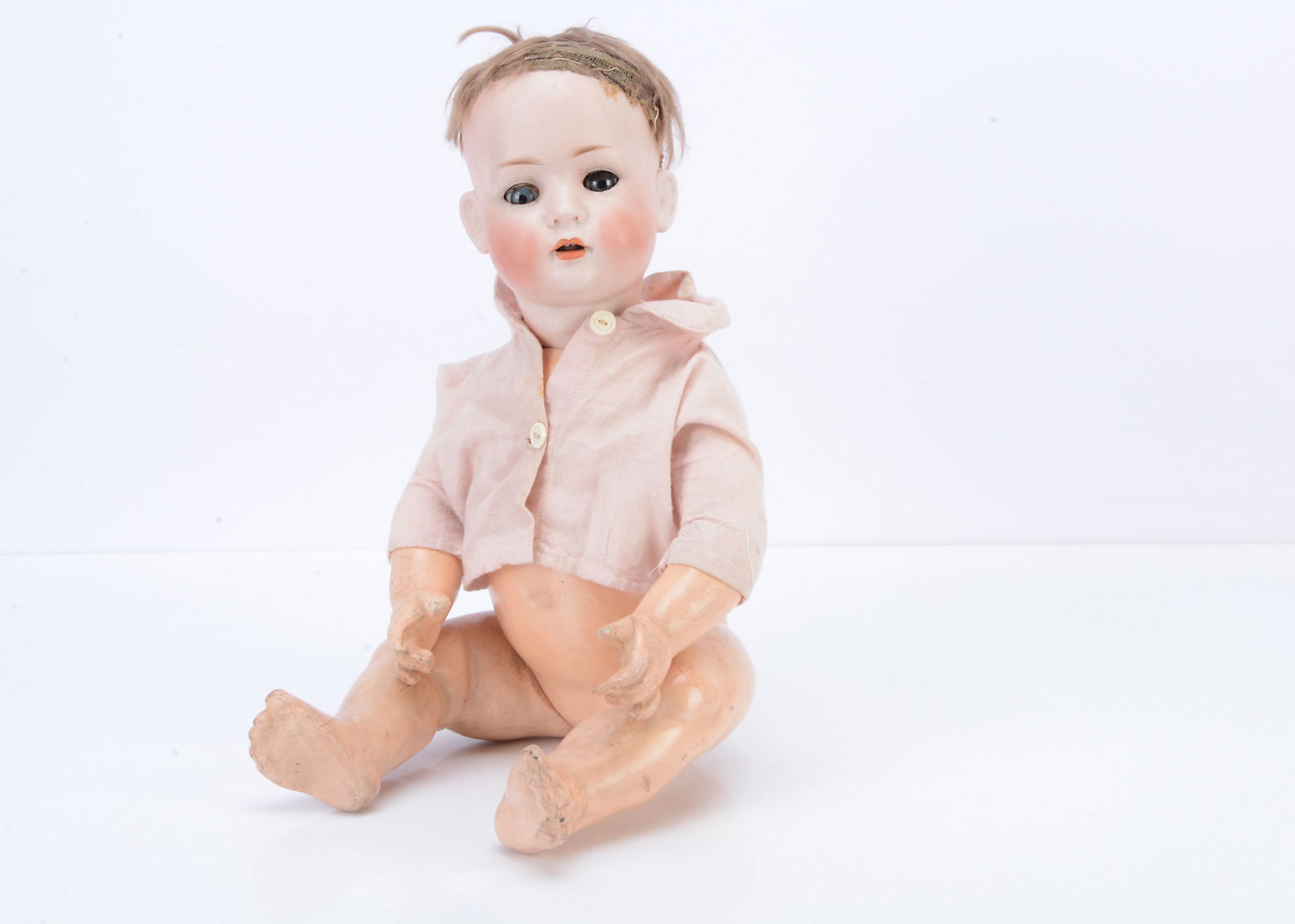 A Bruno Schmidt 2097 character baby,: A Bruno Schmidt 2097 character baby, with blue lashed sleeping eyes, brown mohair wig, bent-limbed composition body and pink shirt —18in. (46cm.) high (missing some lashes and wig sparce)
