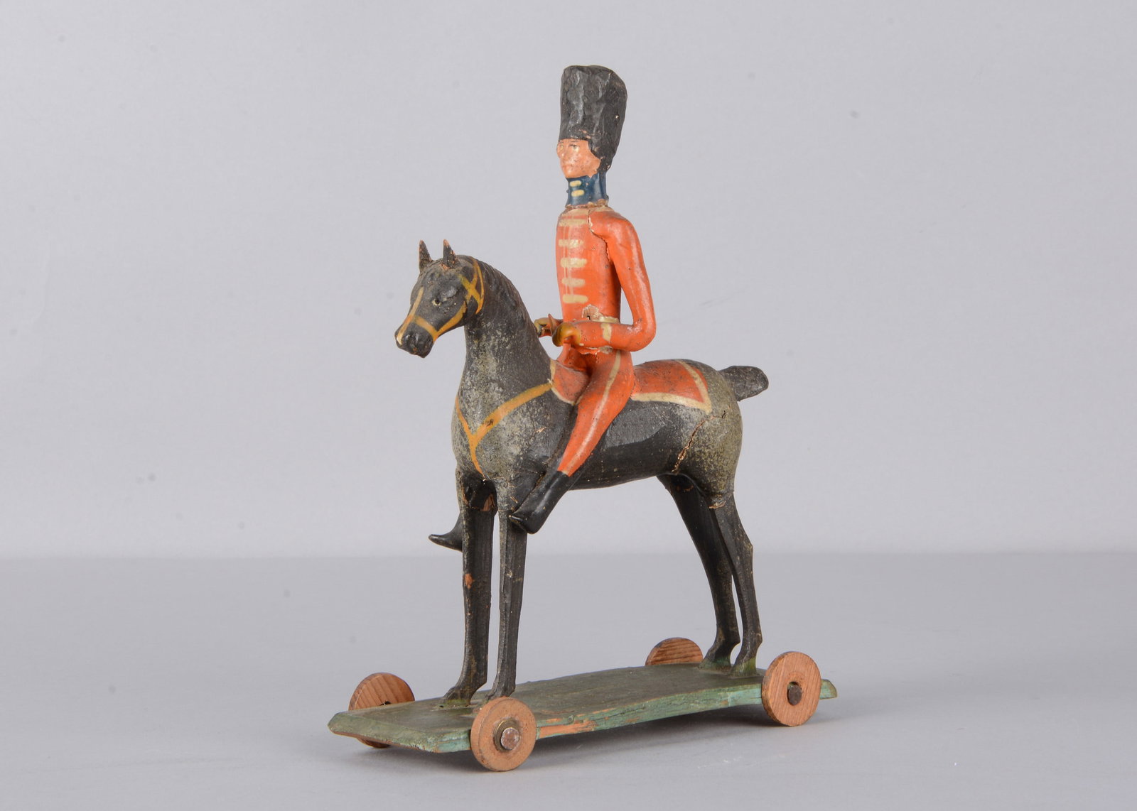 A mid 19th century Thüringen composition and wood British mounted soldier pull along toy, (1 of 6)