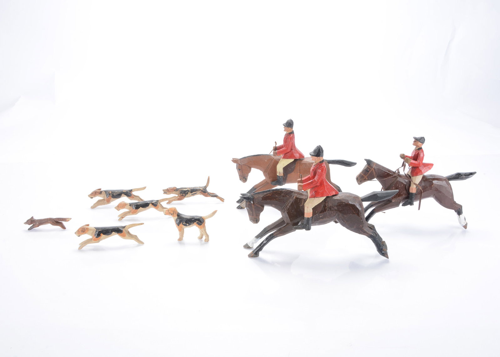 A Forest Toys of Brockenhurst hunt,: A Forest Toys of Brockenhurst hunt, three galloping horses with riders in riding pinks —8 ½in. (21.5cm.) long, four running hounds, a running fox and a standing hound (horses ears, one dama
