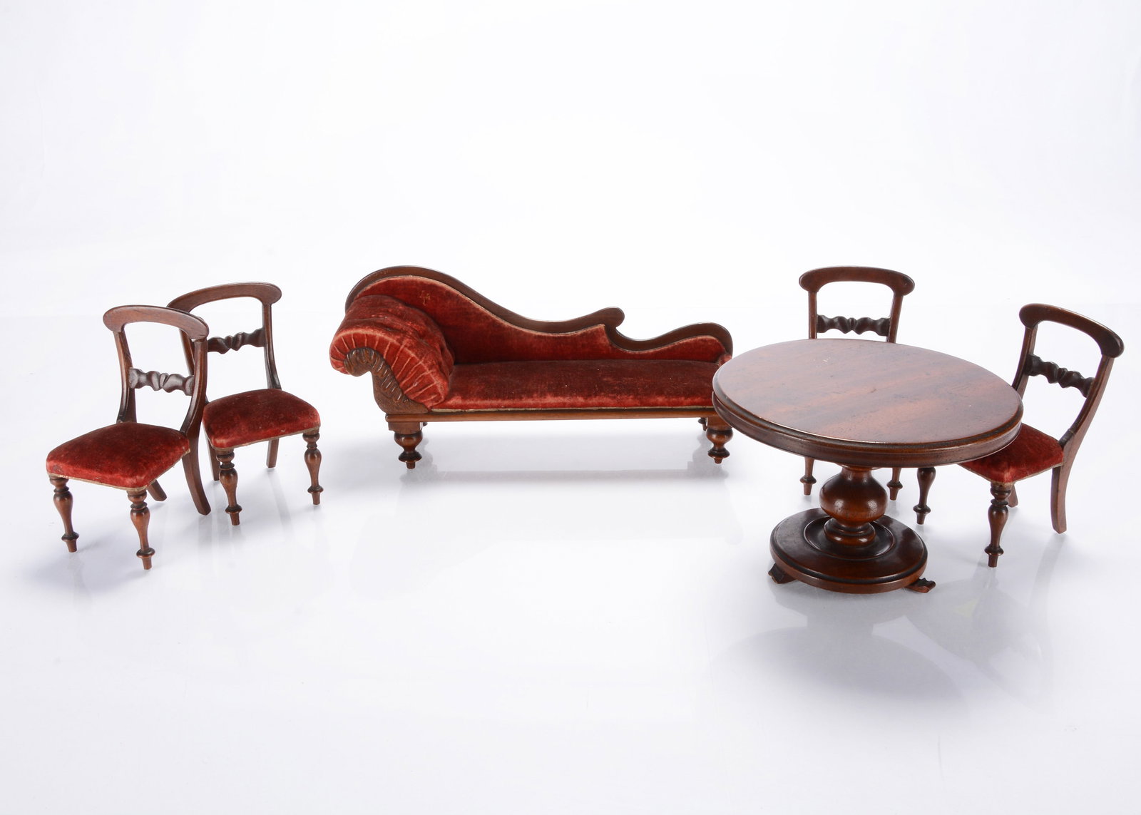 A mid 19th century doll’s or large scale dolls’ house drawing furniture,: A mid 19th century doll’s or large scale dolls’ house drawing furniture, comprising mahogany chaise longue with red velvet upholstery —11in. (28cm.) long, four similar dining chairs