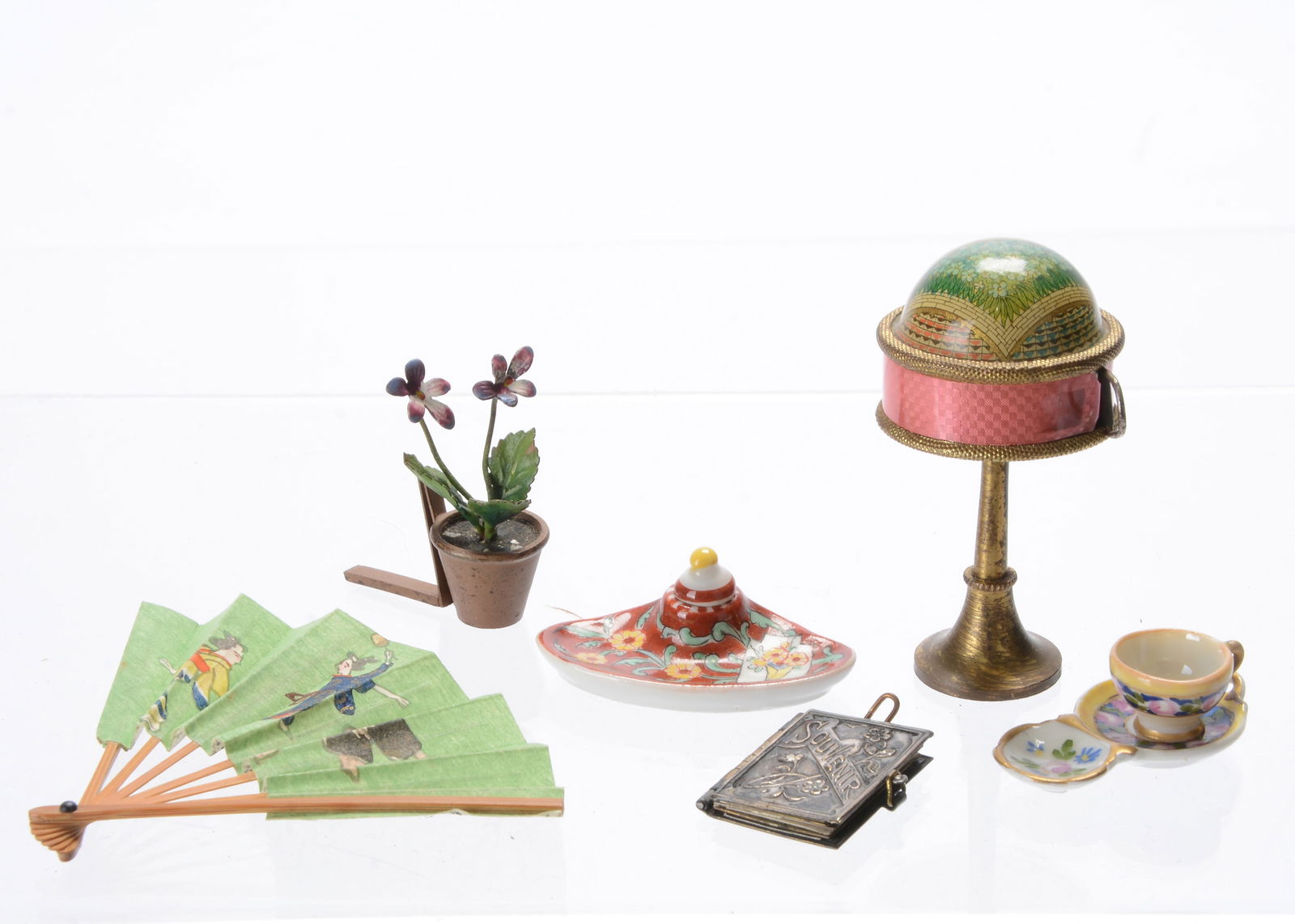 A Limoges dolls’ house ink well,: A Limoges dolls’ house ink well, painted yellow flowers on a dark red ground with lid and signed Limoges —1 ½in. (4cm.) wide, a similar tea cup and saucer with attached biscuit dish;