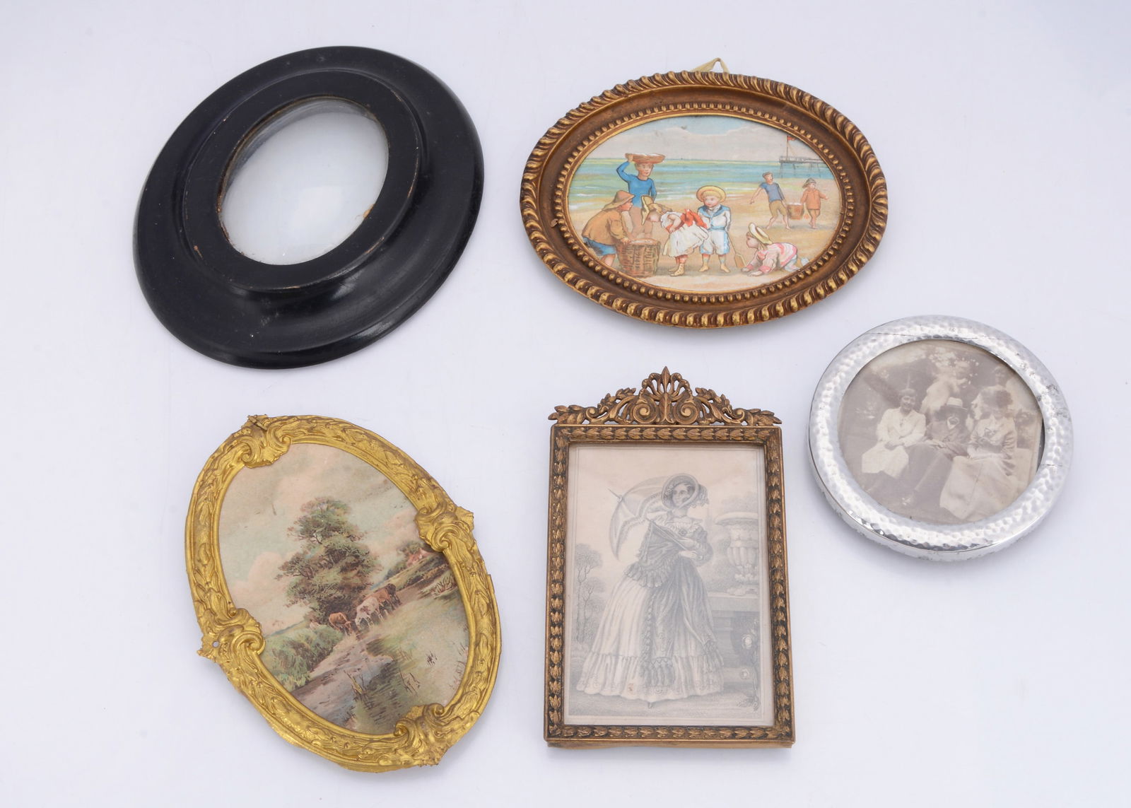 Dolls’ house pictures,: Dolls’ house pictures, two gilt metal oval picture frames —4 ¾in. (12cm.) wide; a brass picture frame, an ebonised wood oval miniature frame with wax seal on back and a round pewter p