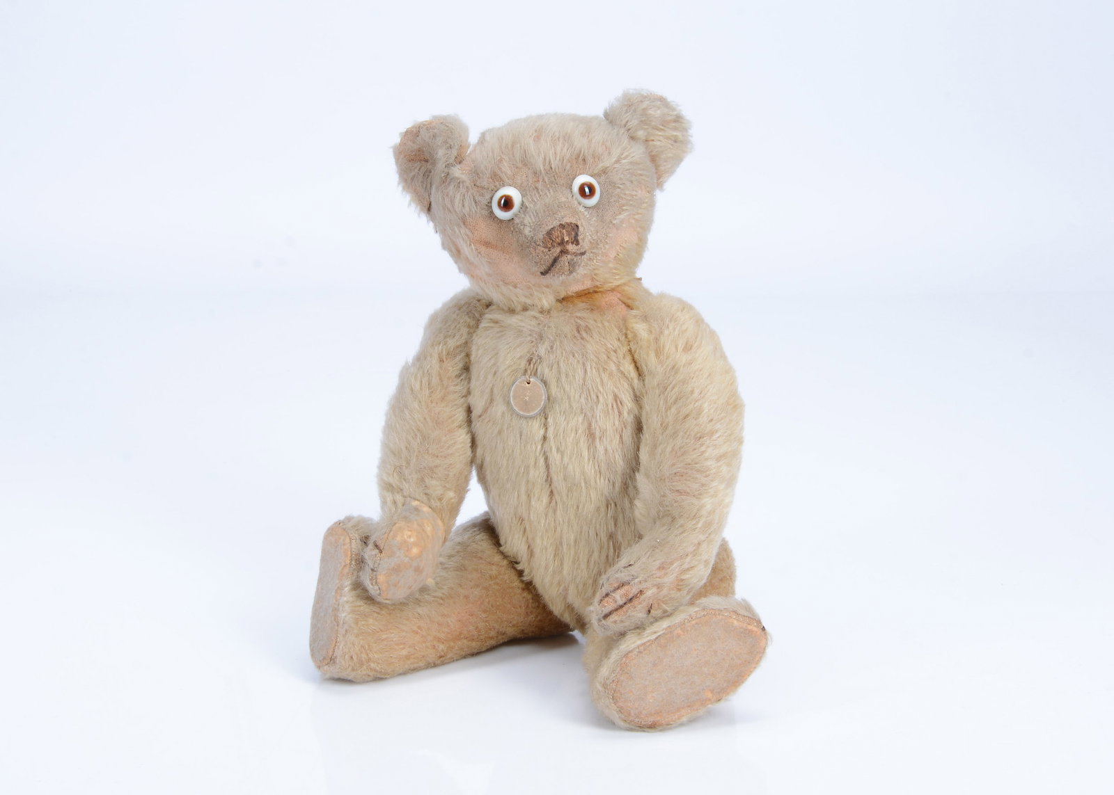 A rare British googly-eyed teddy bear possibly Farnell for Einco, circa 1915,: A rare British googly-eyed teddy bear possibly Farnell for Einco, circa 1915, with golden mohair, pronounced clipped muzzle, white, brown and black glass googly eyes, black stitched nose, mouth and cl