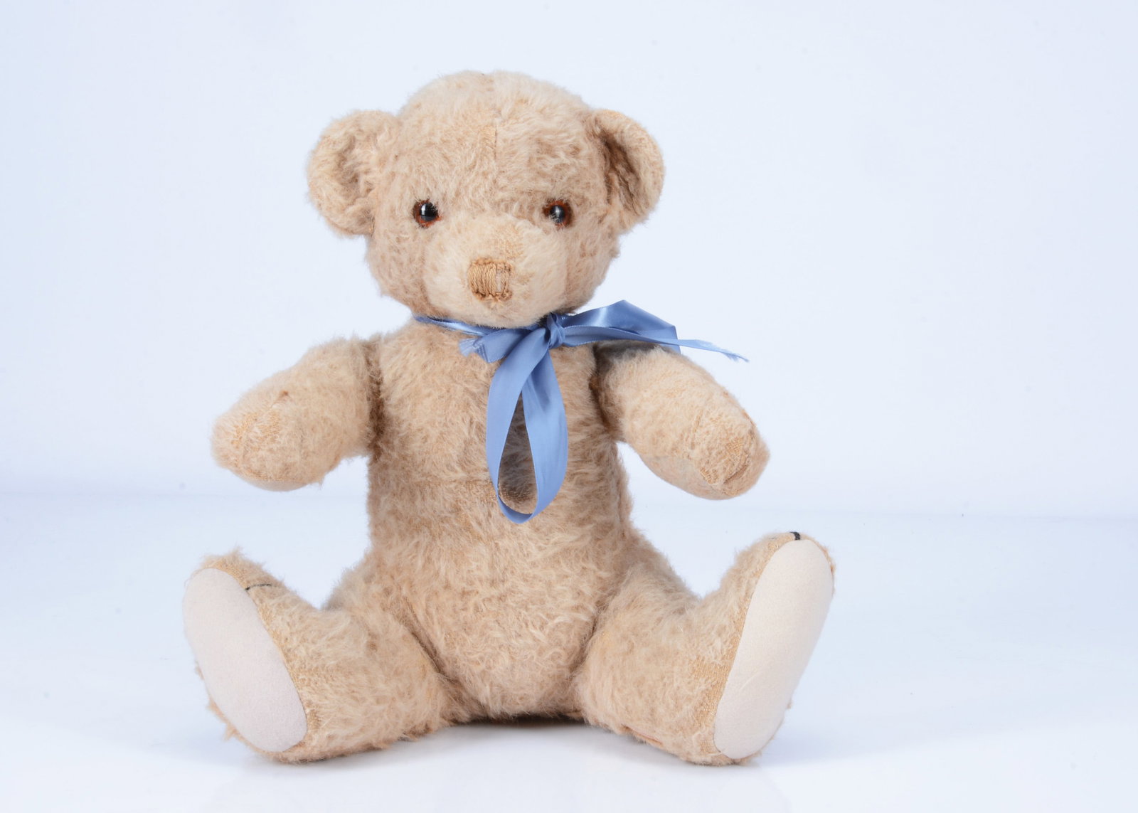 A 1930s Chad Valley Cubby bear cub,: A 1930s Chad Valley Cubby bear cub, with brown and tan alpaca plush, orange and black glass eyes, black stitched nose, mouth and claws, swivel head, inoperative squeaker, seated position and label to 