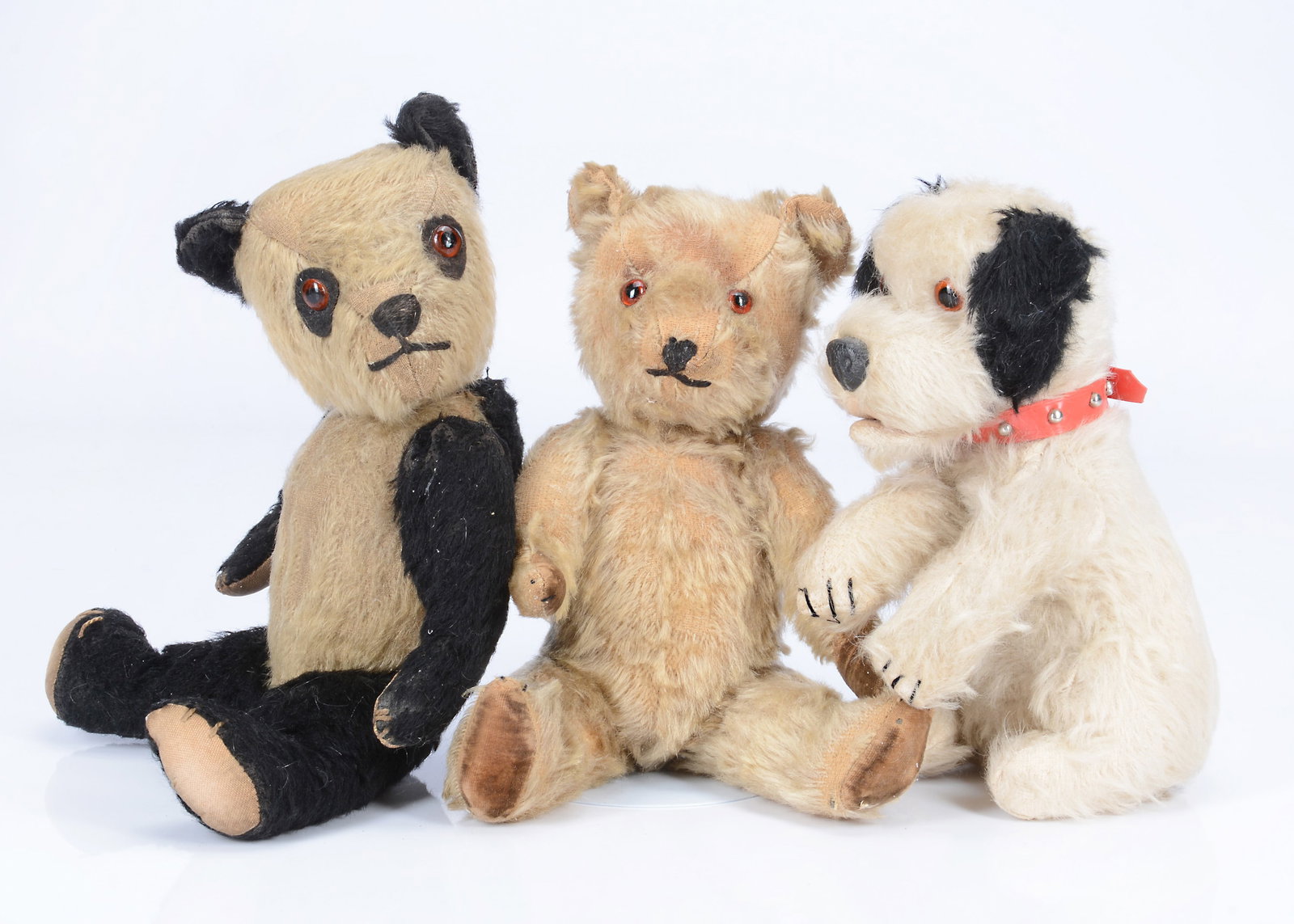 Two post- war Chiltern teddy bears and a dog,: Two post- war Chiltern teddy bears and a dog, Mr Melando a panda with black and white mohair, orange and black glass eyes on black felt backs, black stitched nose and mouth, swivel head, jointed limbs