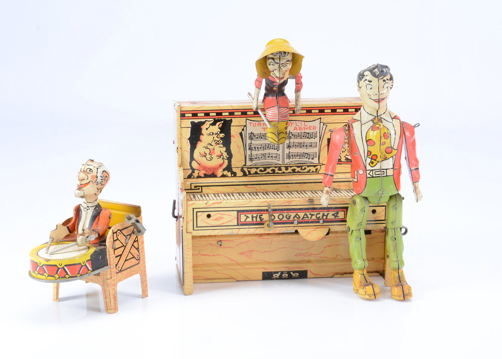 An Unique Art clockwork lithographed tinplate ‘L’Il Abner and The Dogpatch Band’: An Unique Art clockwork lithographed tinplate ‘L’Il Abner and The Dogpatch Band’ toy, surrounding an upright piano —8 1/4in. (21cm.) high (missing pianist and some wear)