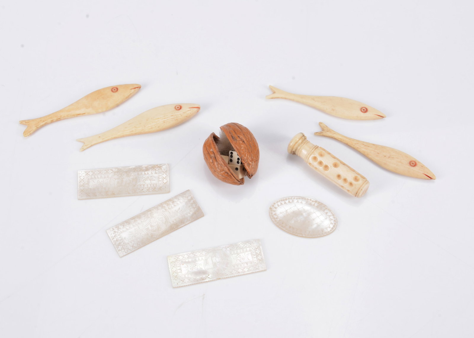 An 19th century walnut shell holding three bone dice, (1 of 1)