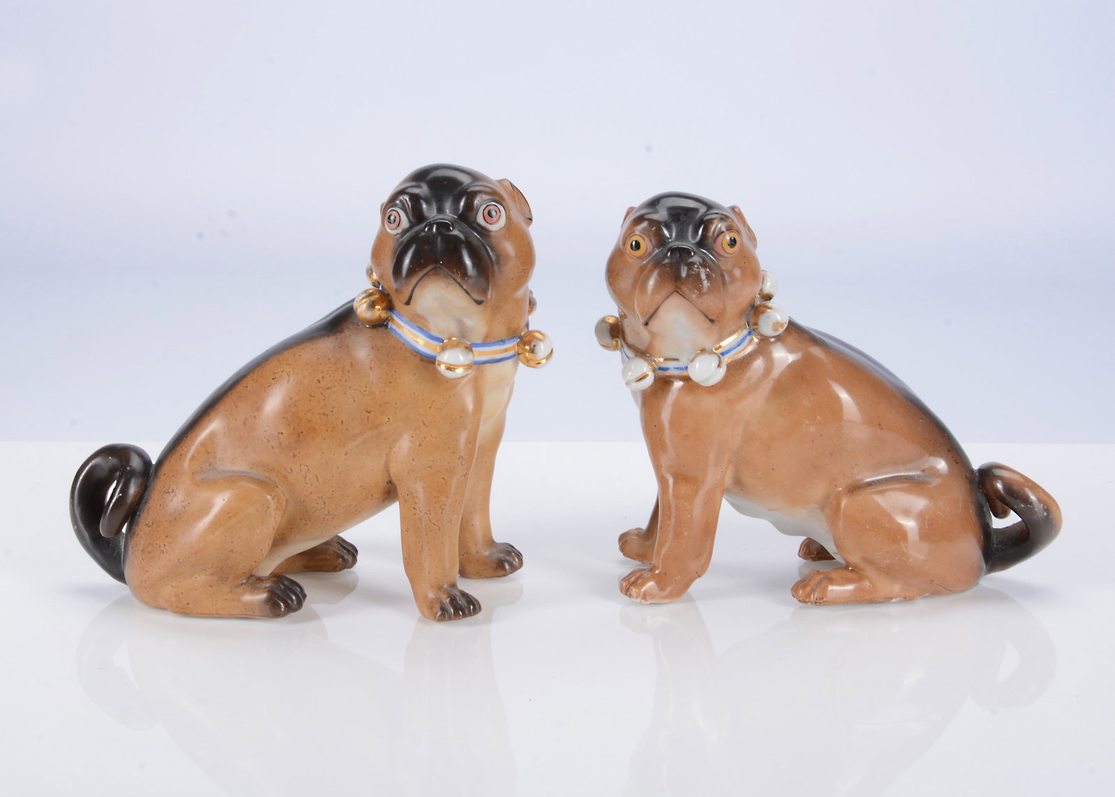 A pair of Conte & Boehme porcelain seated pug dogs, circa 1900, (1 of 2)