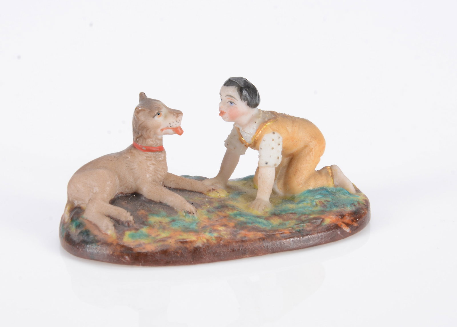 An 19th century German bisque miniature or dolls’ house figure of a boy and dog, (1 of 2)