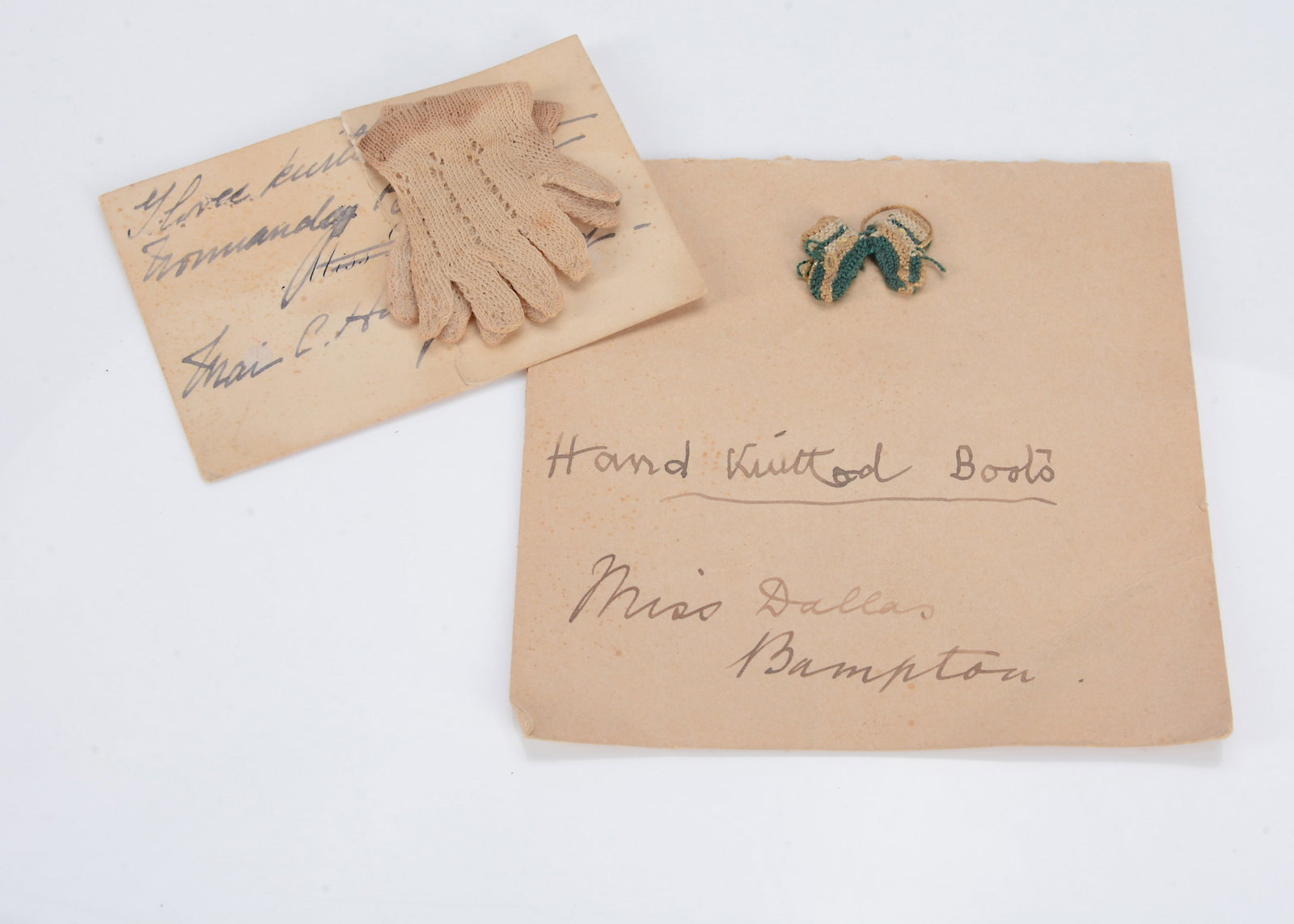 A pair of 19th century hand knitted miniature doll’s boots,: A pair of 19th century hand knitted miniature doll’s boots, in teal and white —1/2in. (1.5cm.) long, stitched to a card with note written in ink ‘Hand Knitted Boots - Miss Dallas Bam