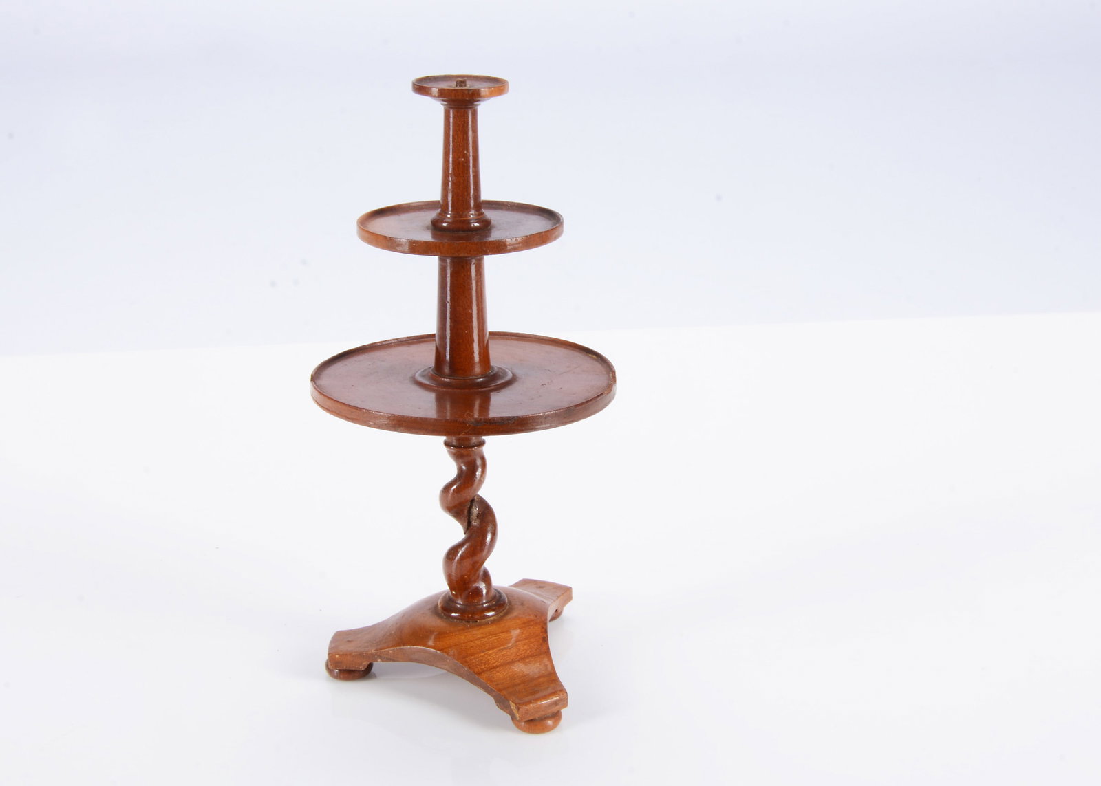 A rare 19th century German turned wood dolls’ house dumb waiter,: A rare 19th century German turned wood dolls’ house dumb waiter, with three circular tiers, barley twist and tripod base, ink price? 3/1 —5 3/4in. (14.5cm.) high (four small chips to botto