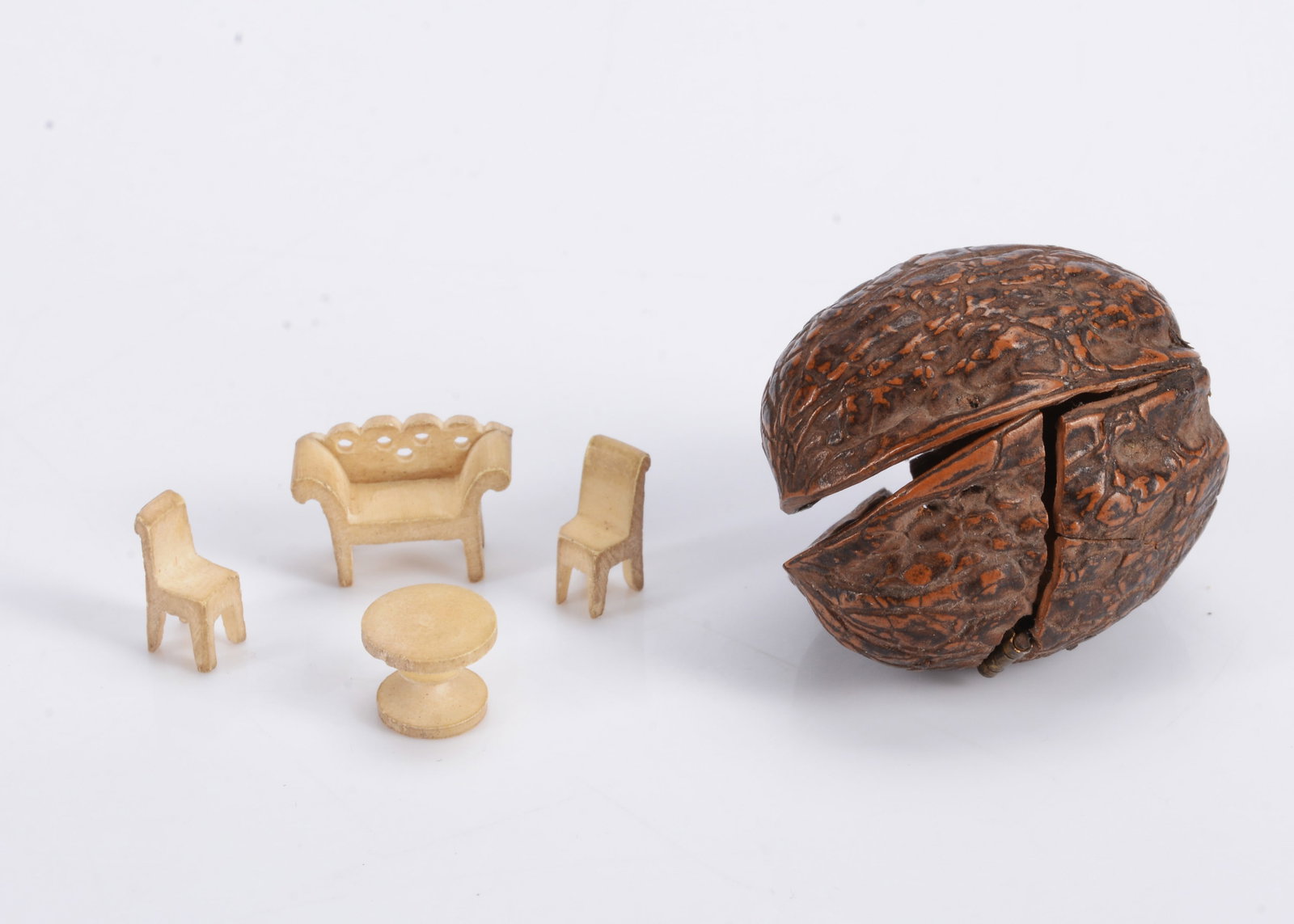 An 19th century walnut shell with a miniature bone dolls’ house set of furniture, (1 of 1)