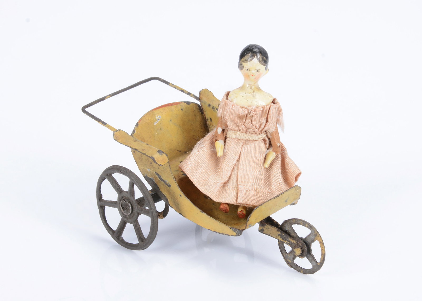An 19th century Grodnertal carved wooden small dolls’ house doll,: An 19th century Grodnertal carved wooden small dolls’ house doll, painted head and shoulders, black eyes, black painted hair with centre parted fringe and curls onto face, wooden body joints at 