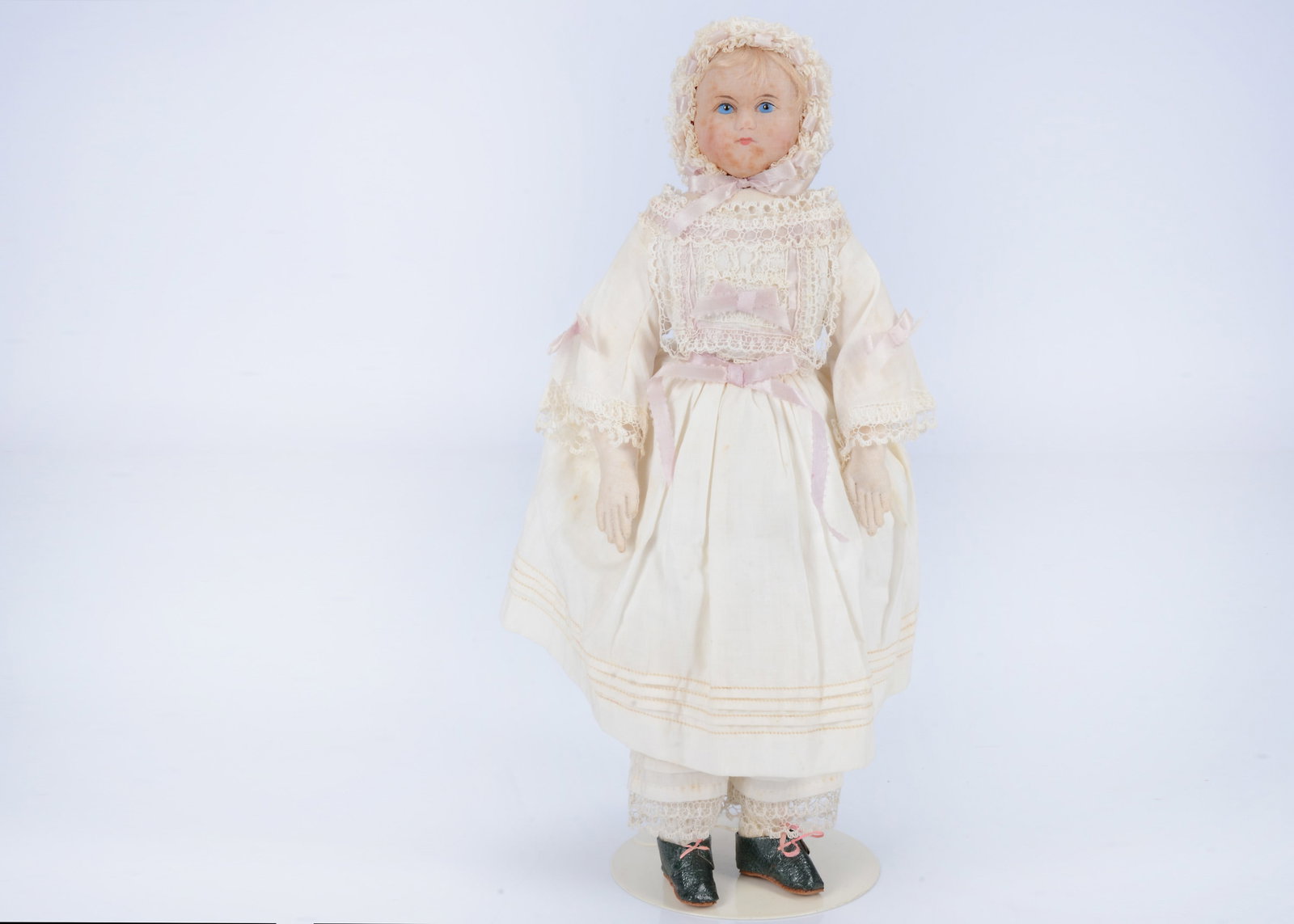 A rare Montanari London Rag Baby wax mask doll, mid 19th century,: A rare Montanari London Rag Baby wax mask doll, mid 19th century, the poured wax mask covered in a fine muslin, bright blue painted eyes with a black headed pin as the pupil, blonde mohair fringe, stu