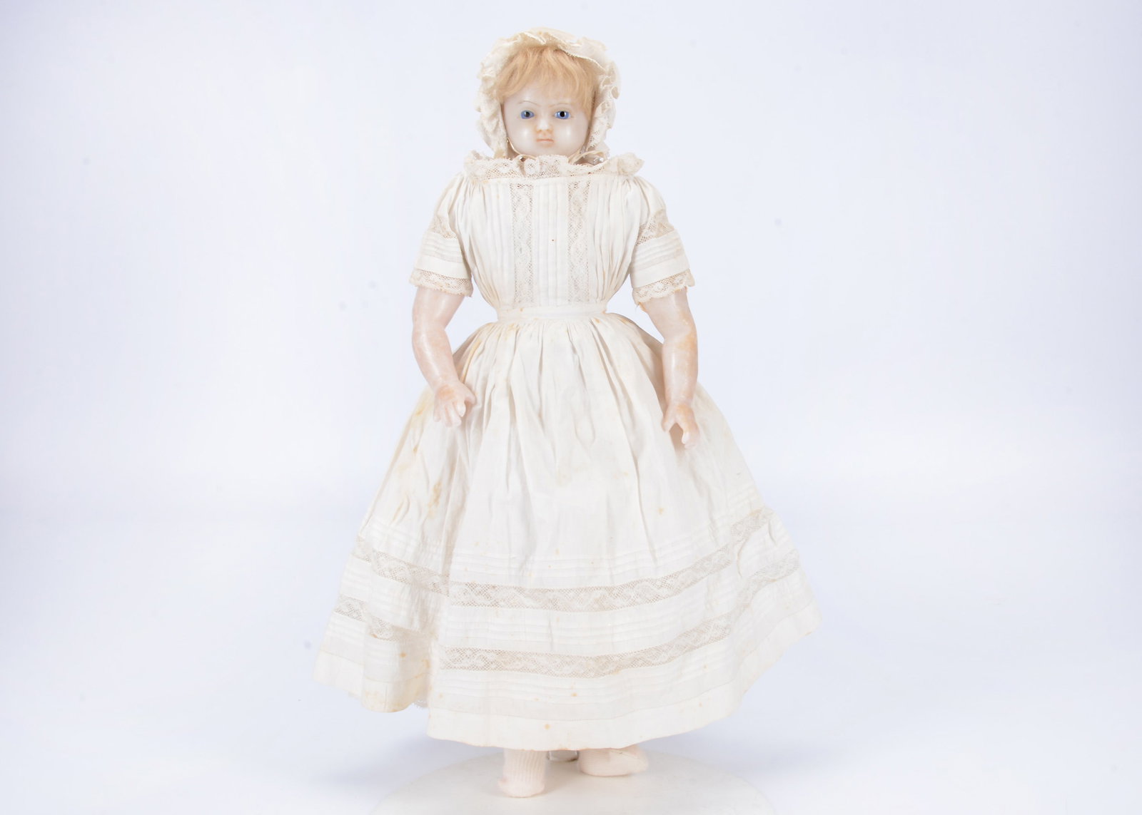 An 19th English poured wax shoulder-head doll,: An 19th English poured wax shoulder-head doll, with blue striated glass eyes, slightly downturned mouth, insert blonde hair, strung to stuffed body with wax limbs, original white cotton dress with lac