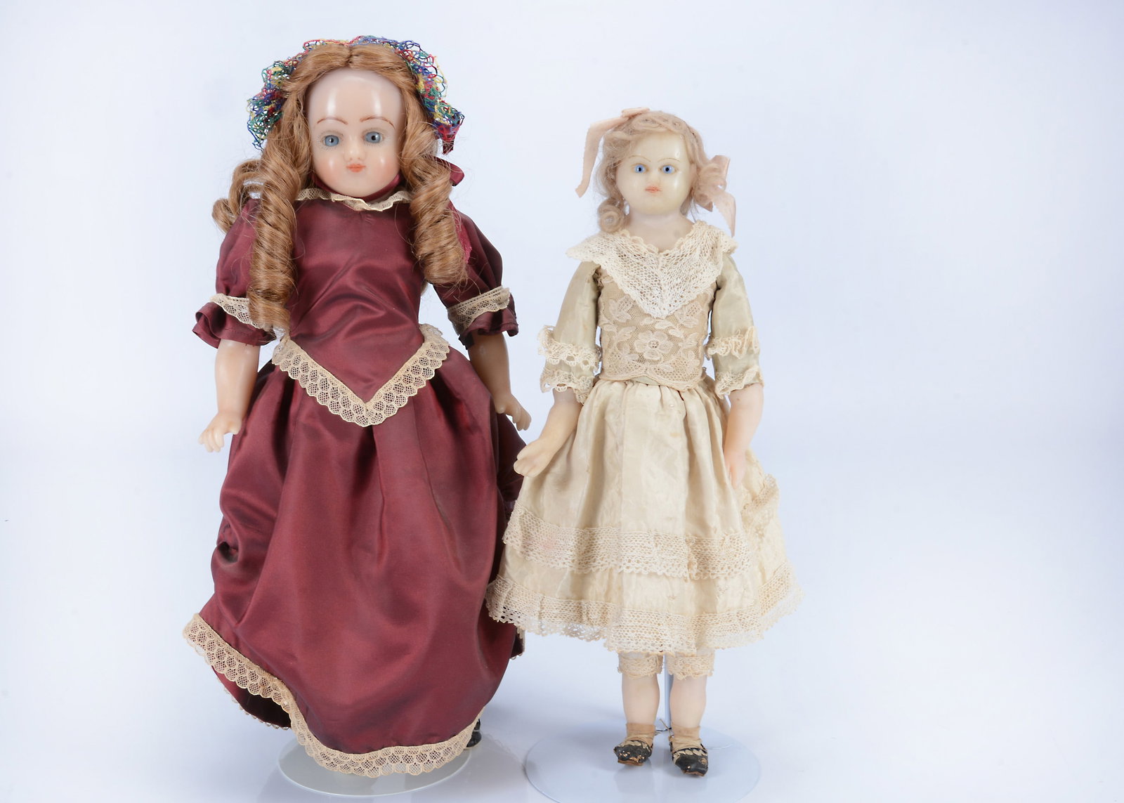 An 19th century English poured wax shoulder head doll,: An 19th century English poured wax shoulder head doll, with blue glass eyes, curly blonde mohair wig, stuffed body with wax limbs and cream dress —15in. (38cm.) high; and a recent poured wax art