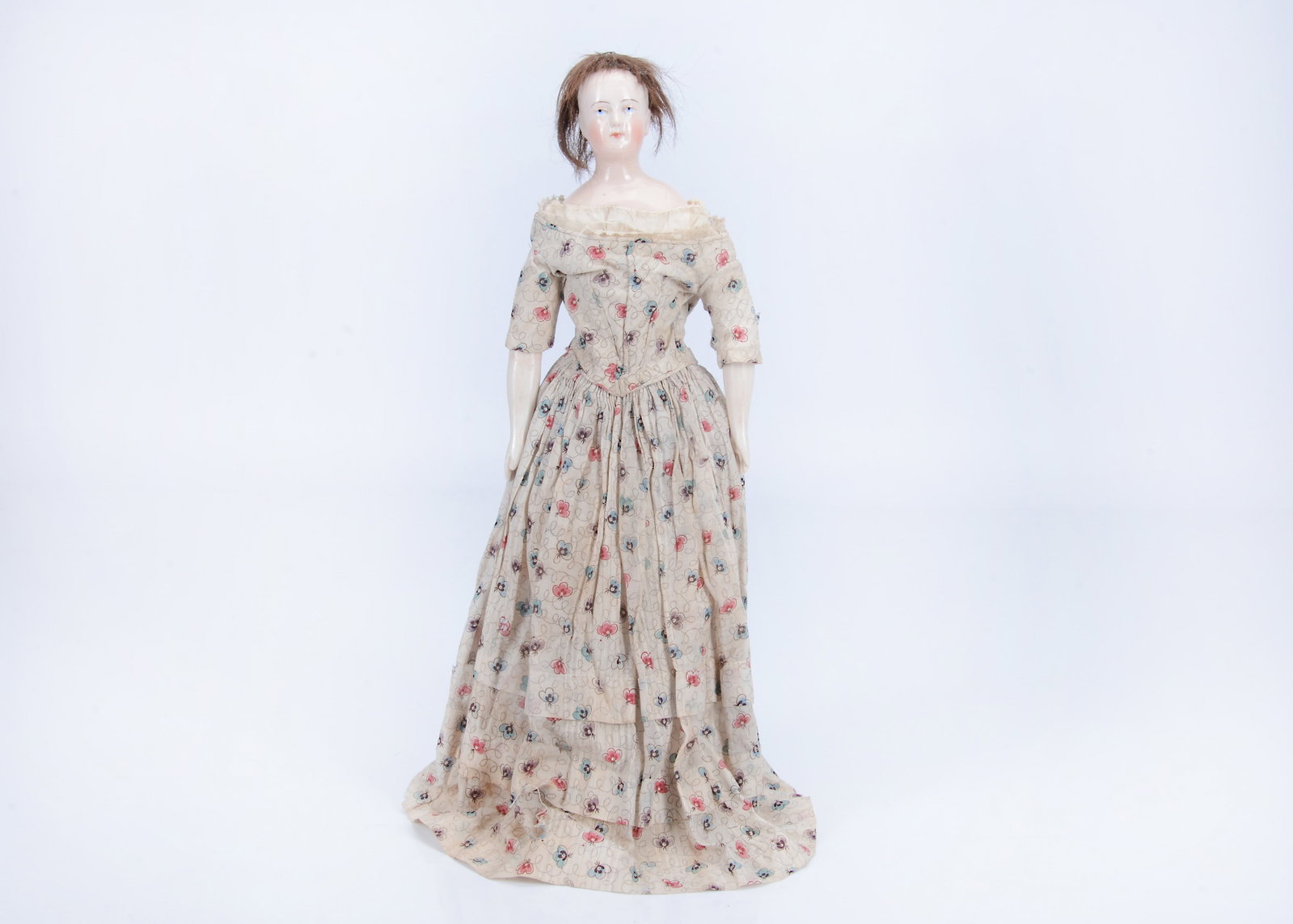 A rare 19th century German pink tinted china shoulder head wigged doll,: A rare 19th century German pink tinted china shoulder head wigged doll, with blue painted upward glancing eyes, red inner eye dash and eyelid line, brown line eyebrows, moulds ears, brown hair wig, st