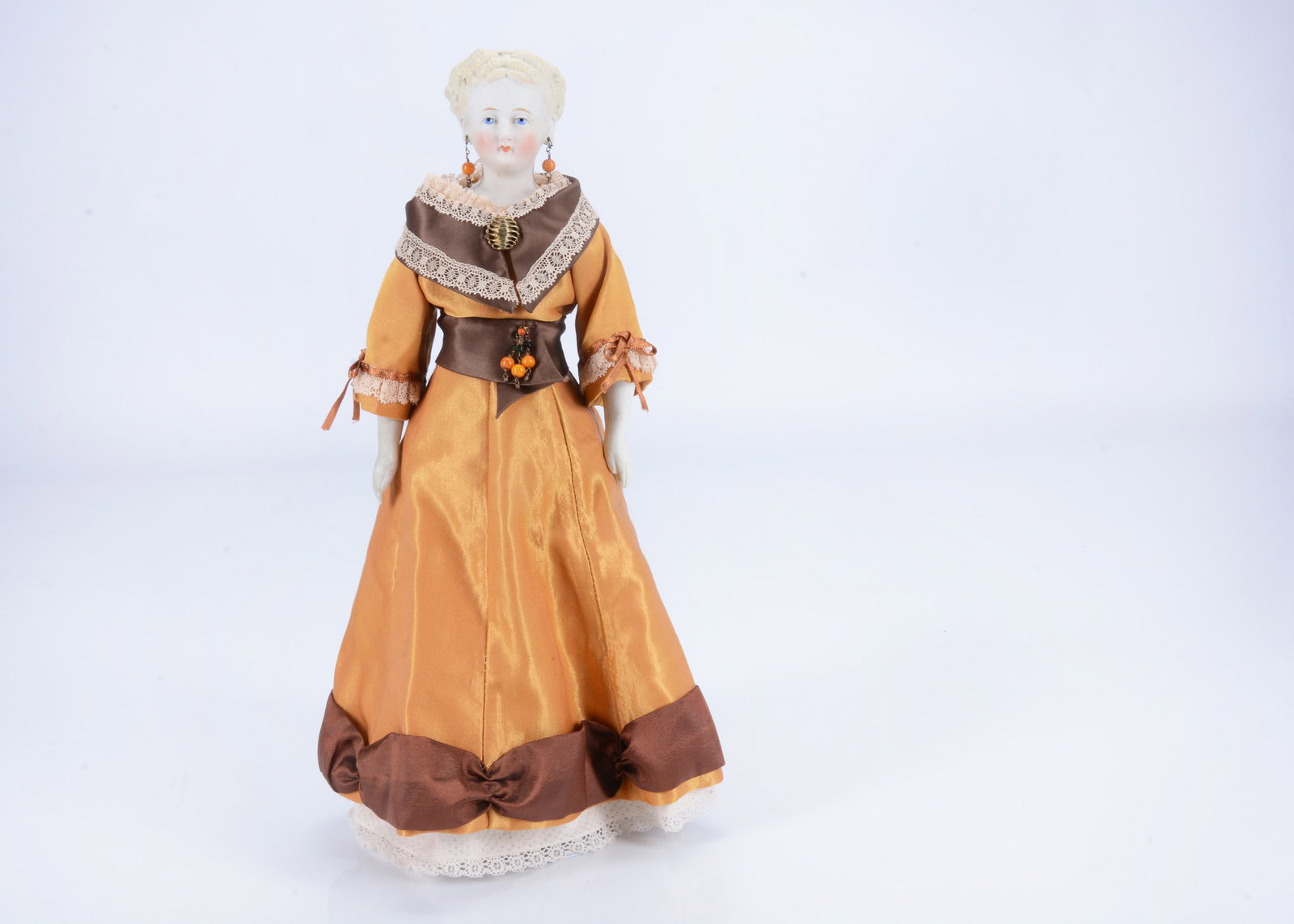 An 19th century German bisque shoulder head doll with elaborately moulded hairstyle,: An 19th century German bisque shoulder head doll with elaborately moulded hairstyle, with deep blue painted eyes, single stroke brow, rosebud painted mouth with unpainted gap, exposed pierces ears, bl