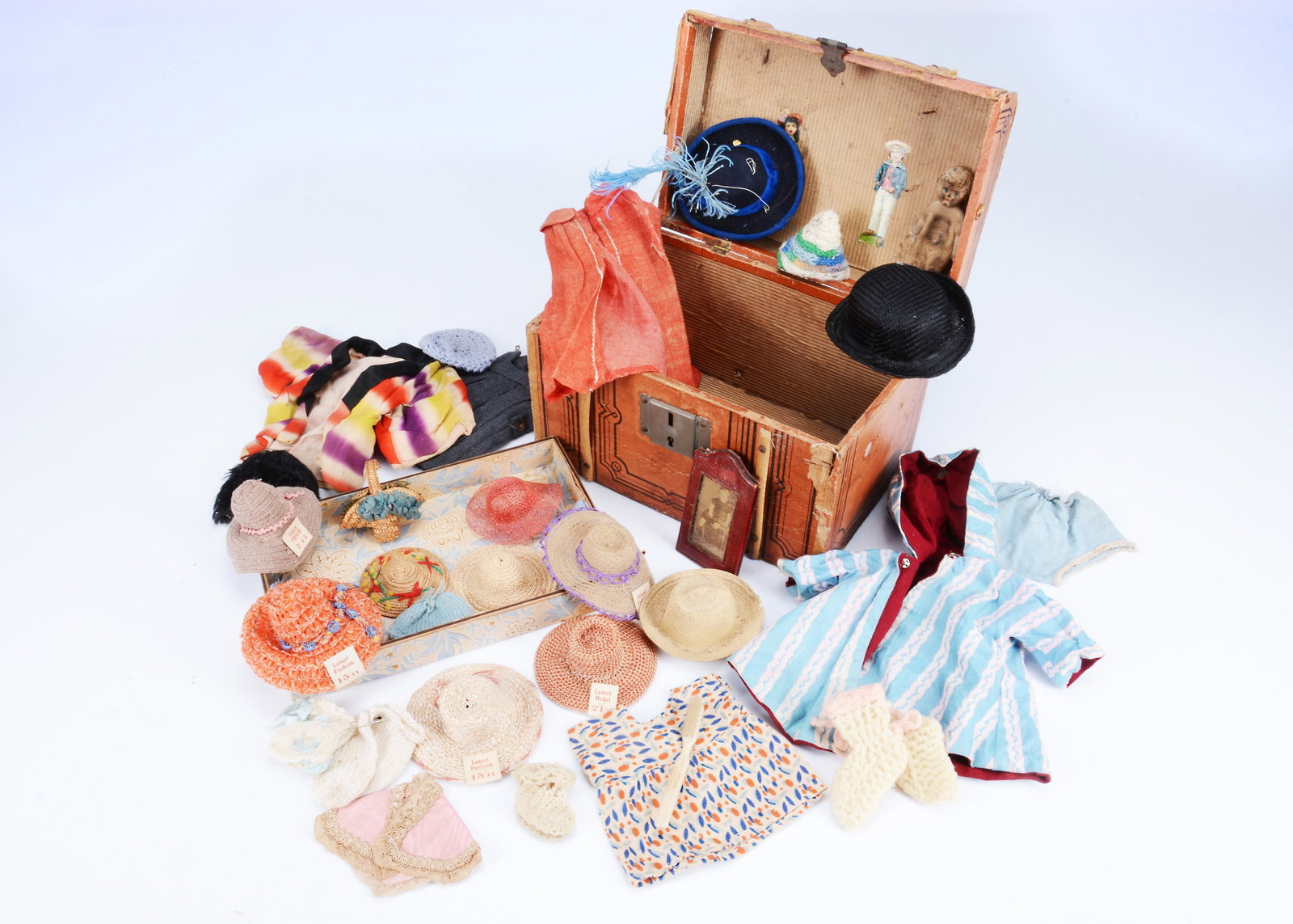 A selection on early 20th century small doll's clothes with trunk, (1 of 2)