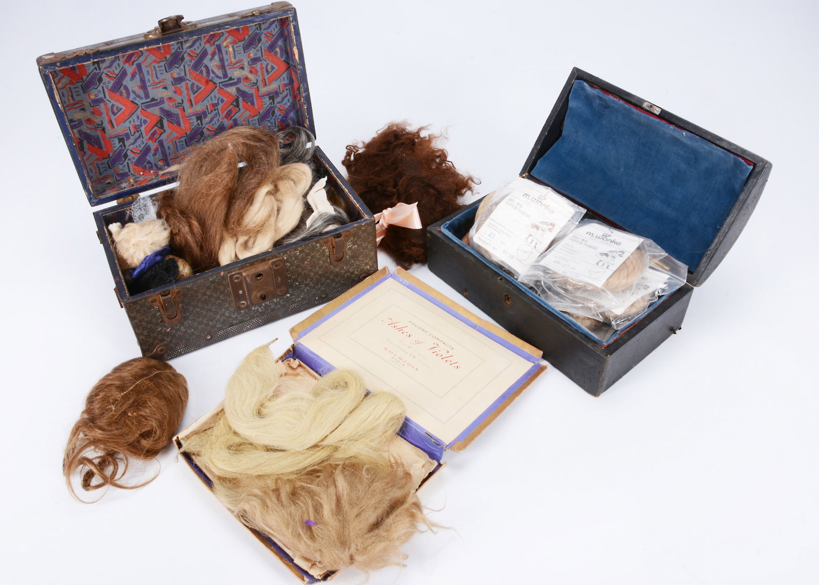 Two small dolls trunks containing wigs, (1 of 2)