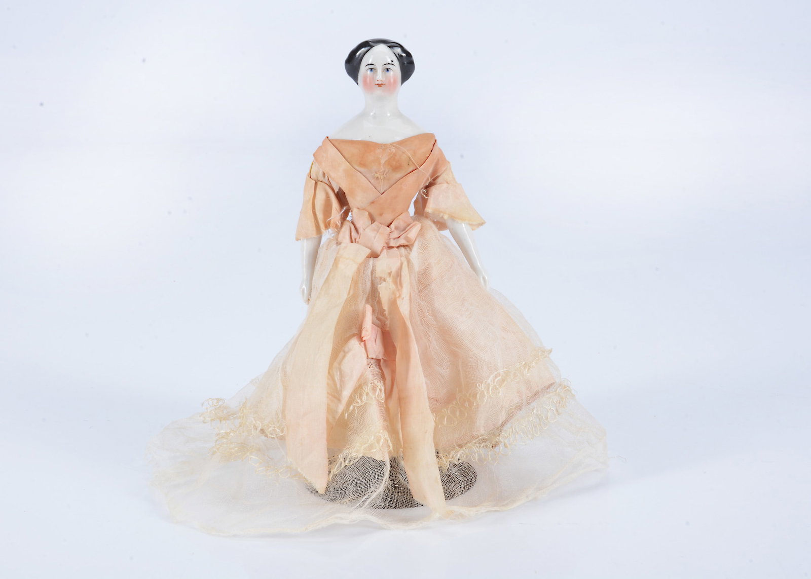 An 19th century German large scale dolls’ house china shoulder head doll,: An 19th century German large scale dolls’ house china shoulder head doll, with blue painted eyes, black painted and moulded swept back centre-parted hair with coiled bun, stuffed body with china