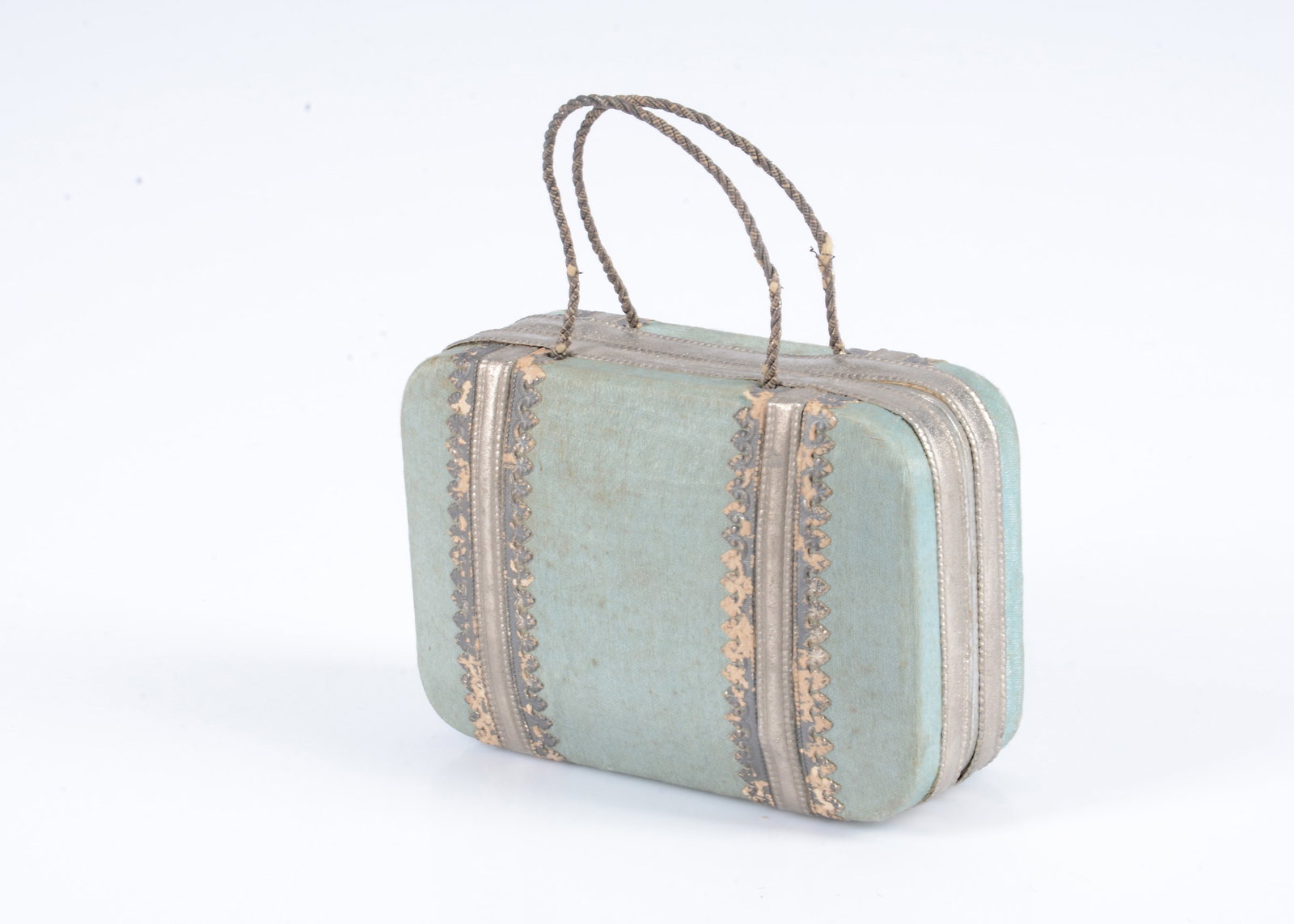 An 19th century French fashion doll’s suitcase sweet container,: An 19th century French fashion doll’s suitcase sweet container, card covered in pale blue silk with silver embossed card trim and silver cord handle —3 ½in. (9cm.) wide