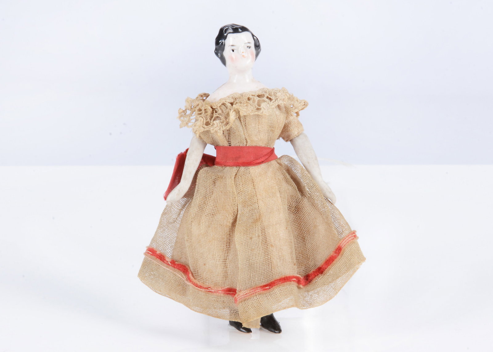 An 19th century German china shoulder-head dolls’ house girl doll,: An 19th century German china shoulder-head dolls’ house girl doll, with black painted eyes, black painted and moulded hair, stuffed body with bisque limbs and black painted flat soled boots, ori