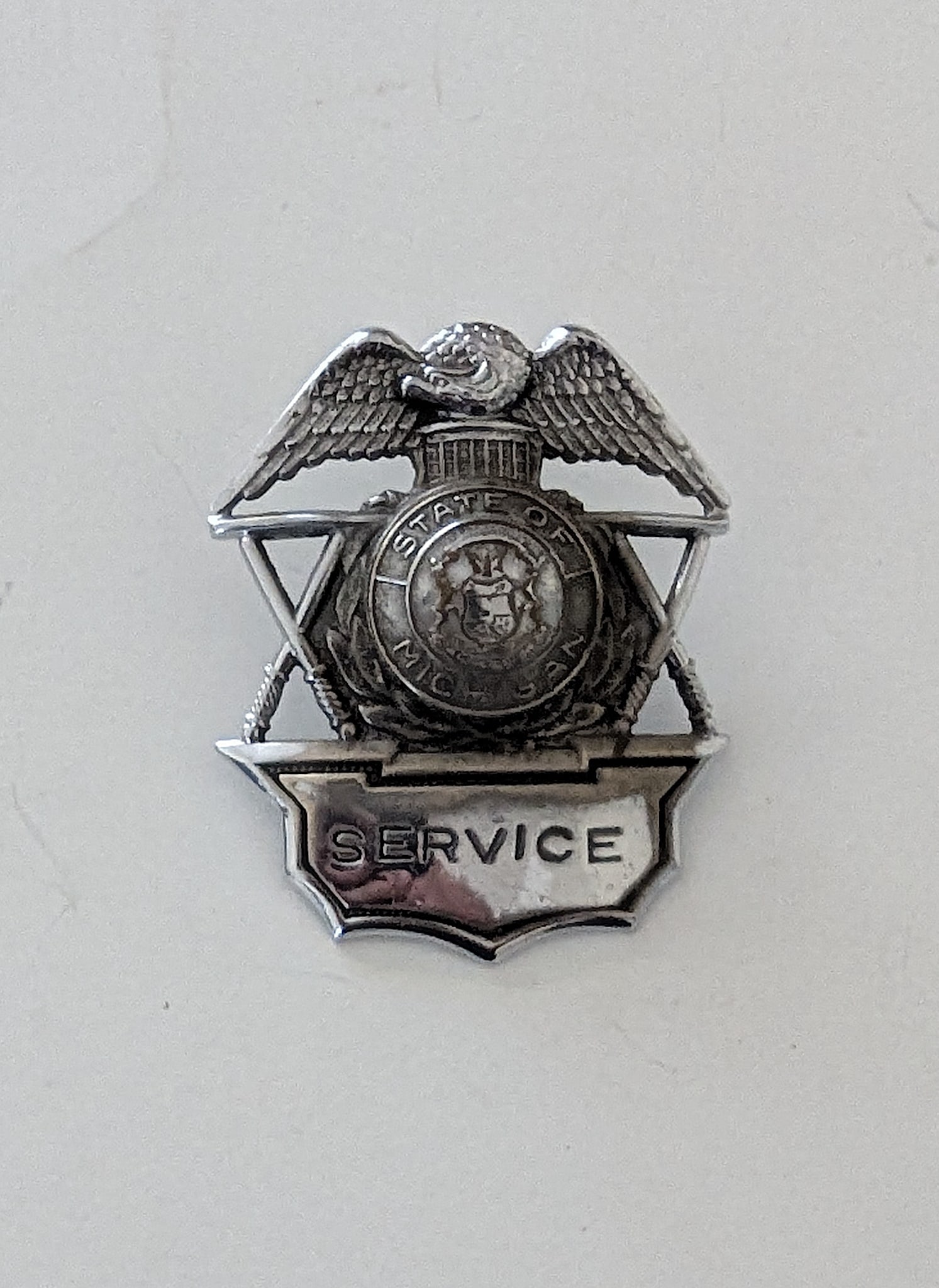 Vintage SERVICE Badge - State Of Michigan: The provenance of this lot is from a quality collector PBC. Please see all the included images to read all related information. We have included quality scans to show it's actual condition. This lot i