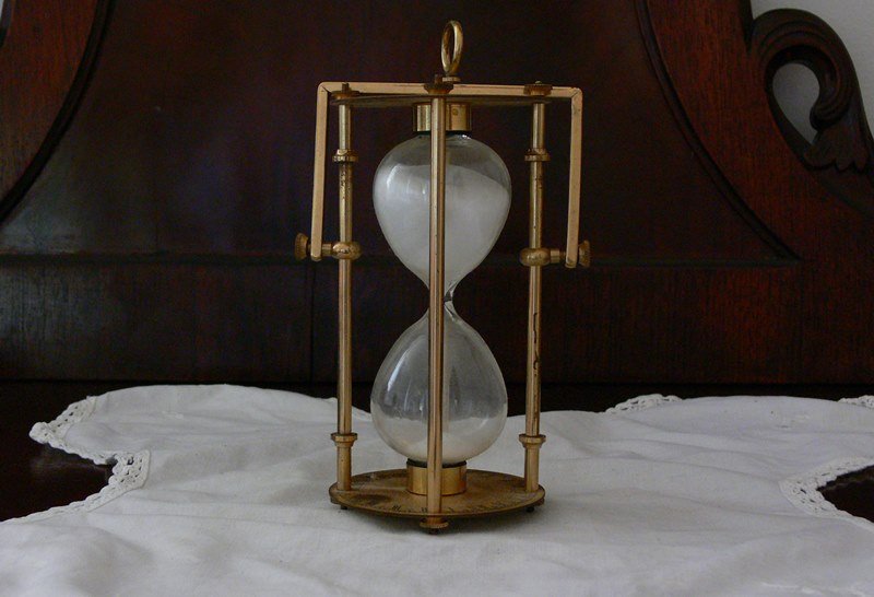 Vintage old gold metallic sand clock with hanger.: The dimensions are 3" diameter and 6"H without hanger and 8"H hanged. This piece is located in Boca Raton, Fl.