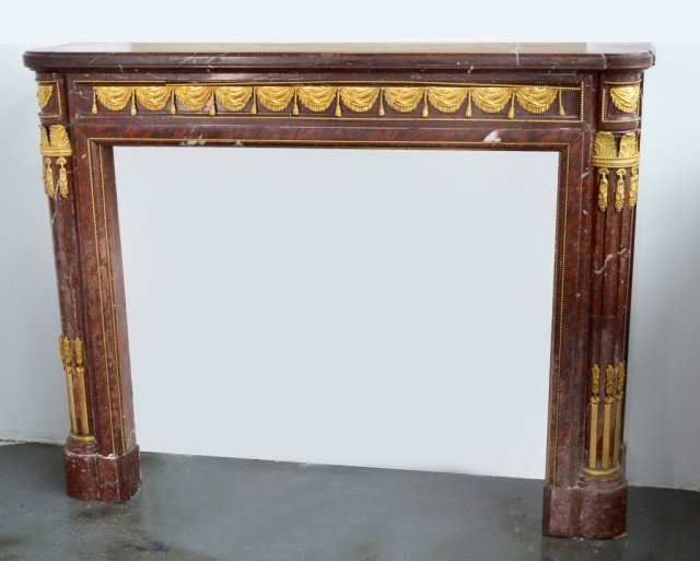 Rouge De Rance Marble Mantle: Gilt Bronze mounted leaf and swag decoration. Rectangular molded top, fluted supports. Height 48 inches, width 62 inches, depth 16 inches.