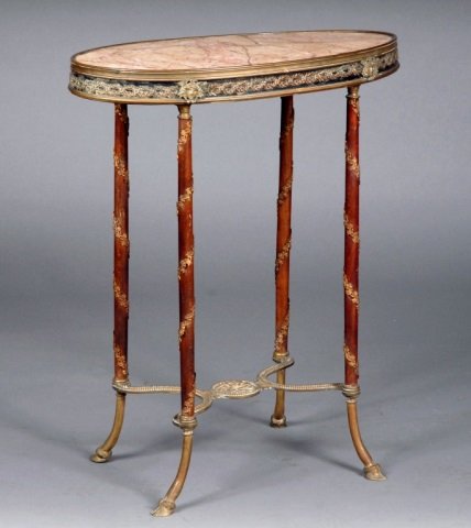 Louis XVI Style Occasional Table: Oval mottled marble top, raised on turned legs with bronze mounted decoration and bronze neoclassical stretcher. Height 29 inches, width 23 inches, depth 13 inches.